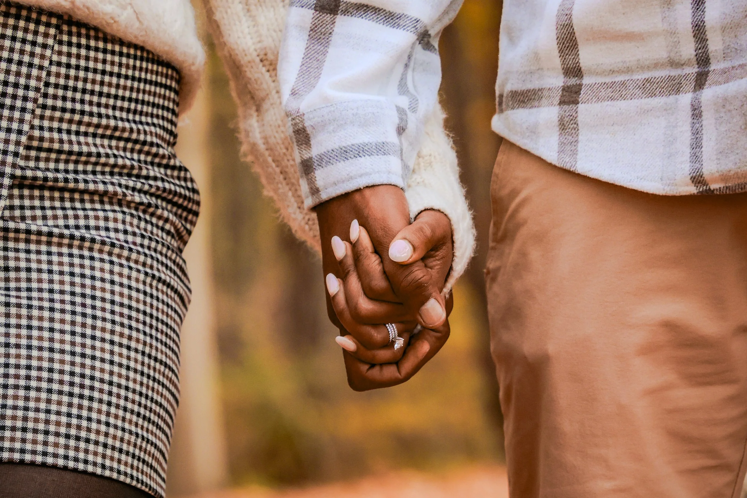 Married couple holding hands during couples photo session in the fall at a park taken by Indianapolis couples photographer
