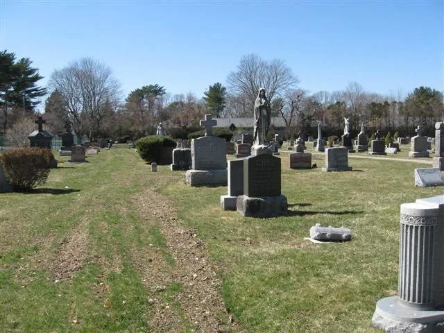 gravestones with large statue of blessed mother