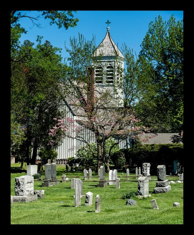 old tombstones  with view of blooming cherry tree and church in background