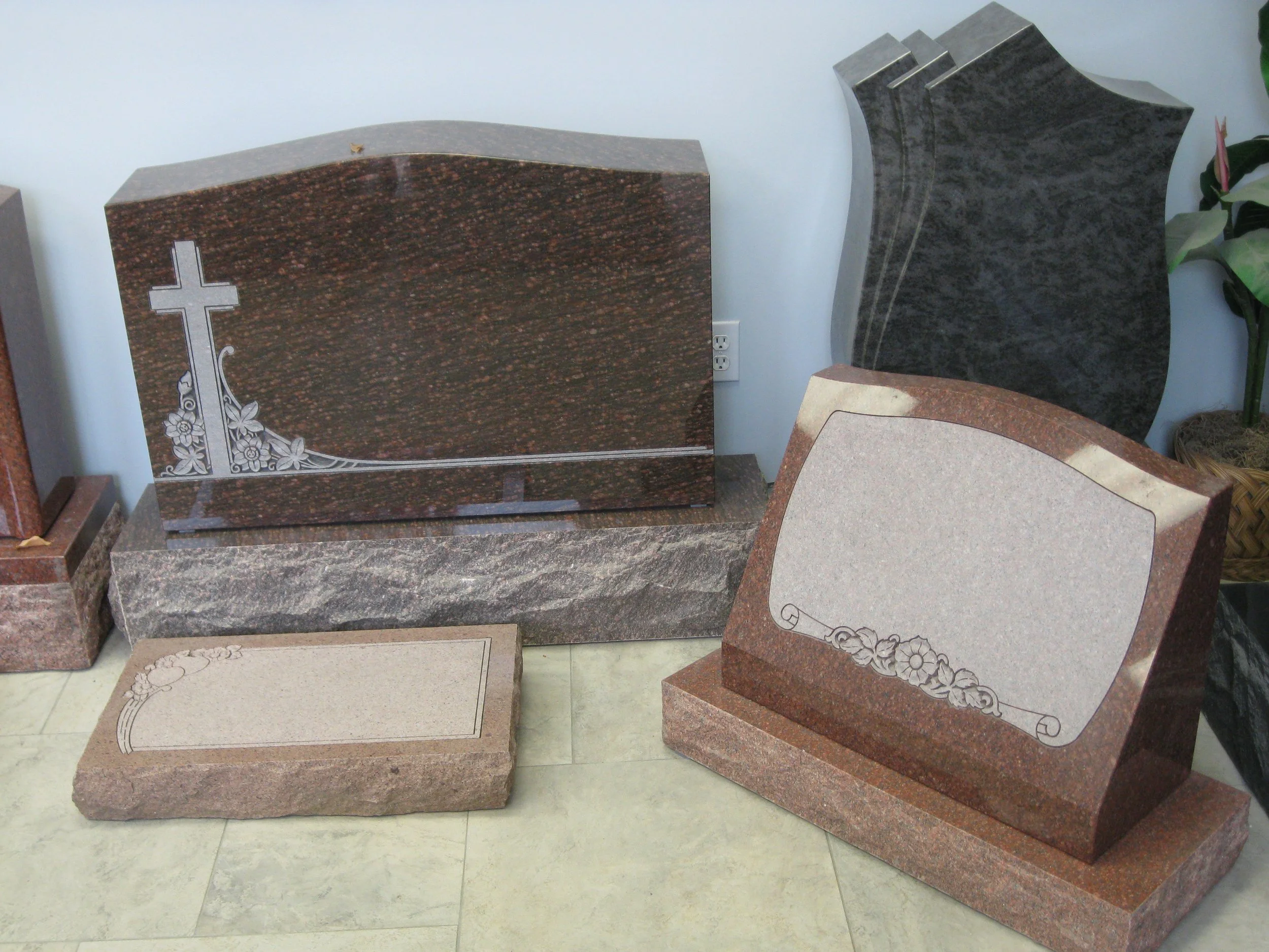 Various granite and marble headstones arranged in a display area.