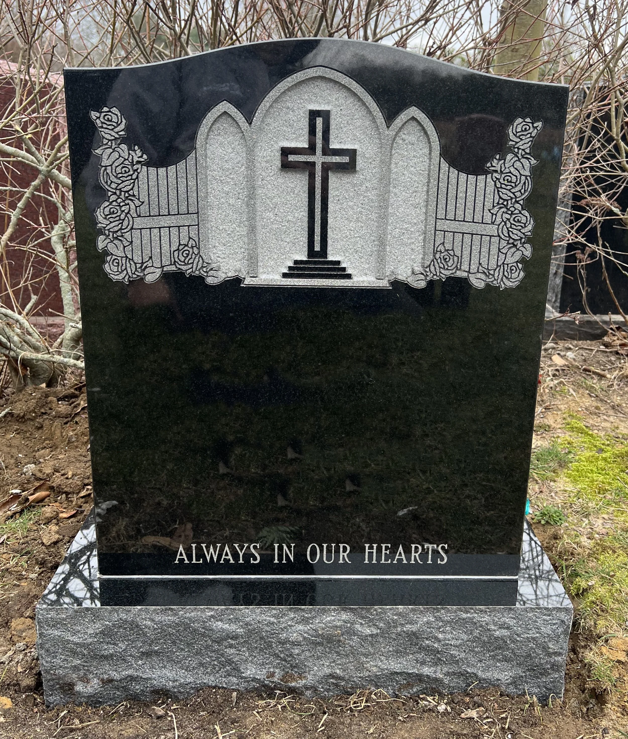 Black monument with cross and gate