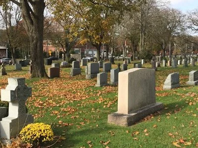 gravestones amid scene of fallen autumn leaves