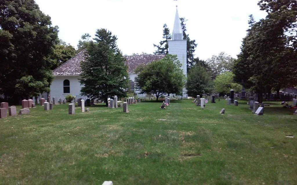 historic white church with cemetery in foreground