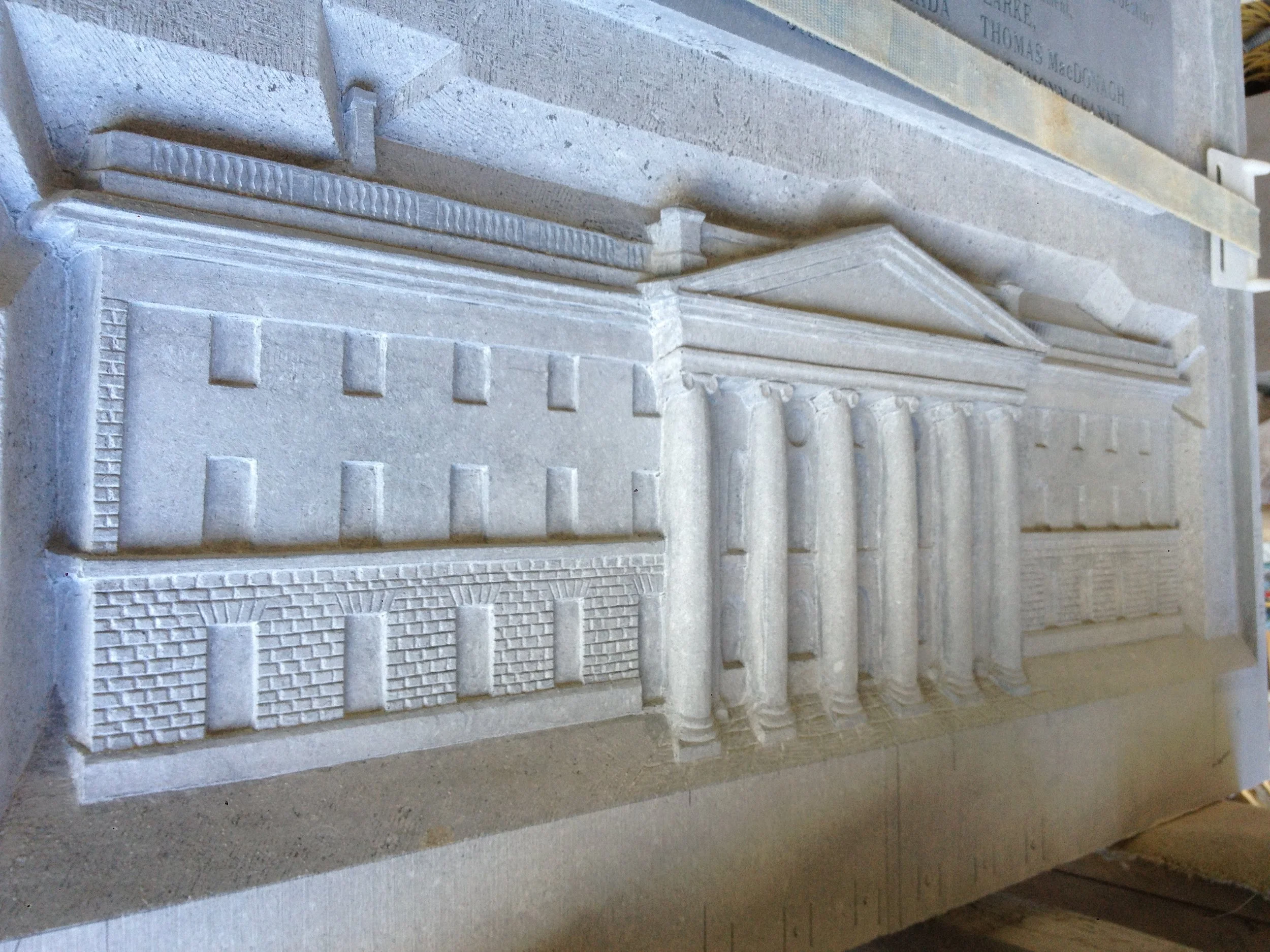 Close-up view of an engraved stone memorial or monument with detailed carvings and inscriptions.