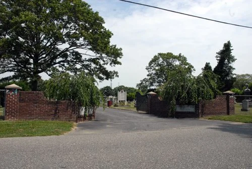 brick wall with open gate, driveway into cemetery