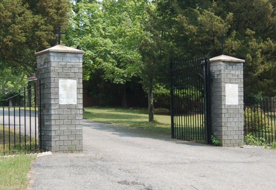 Gate of cemetery with grey brick pillars