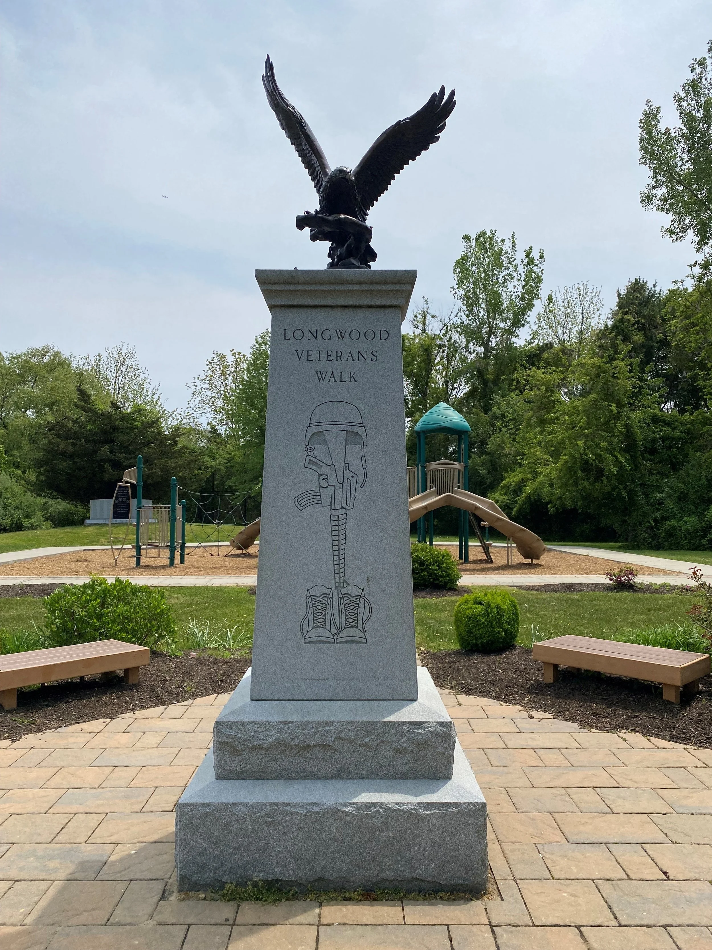 Grey granite pedestal with bronze eagle ont op 