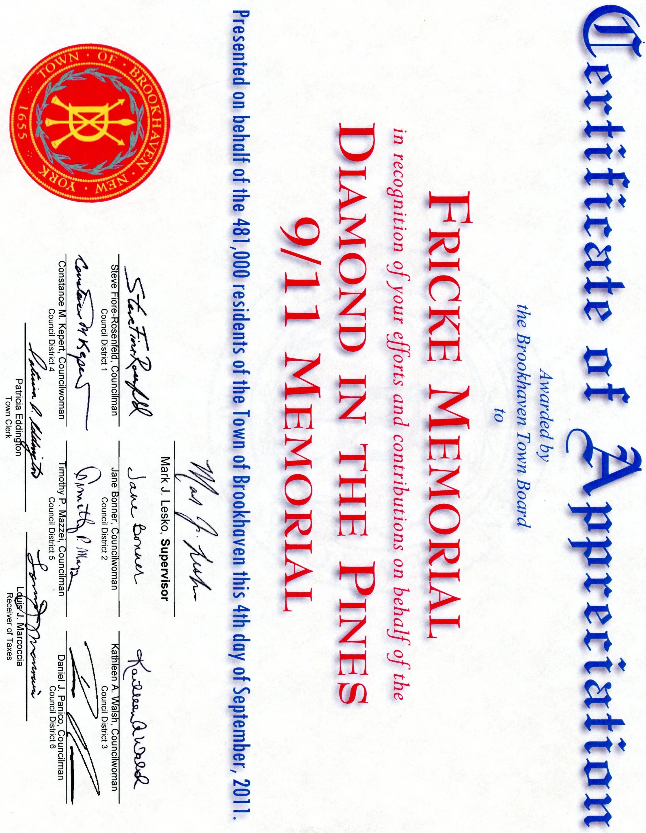 A printed certificate or official document with signatures, a red and gold emblem, and text in blue and red. The document is oriented sideways.