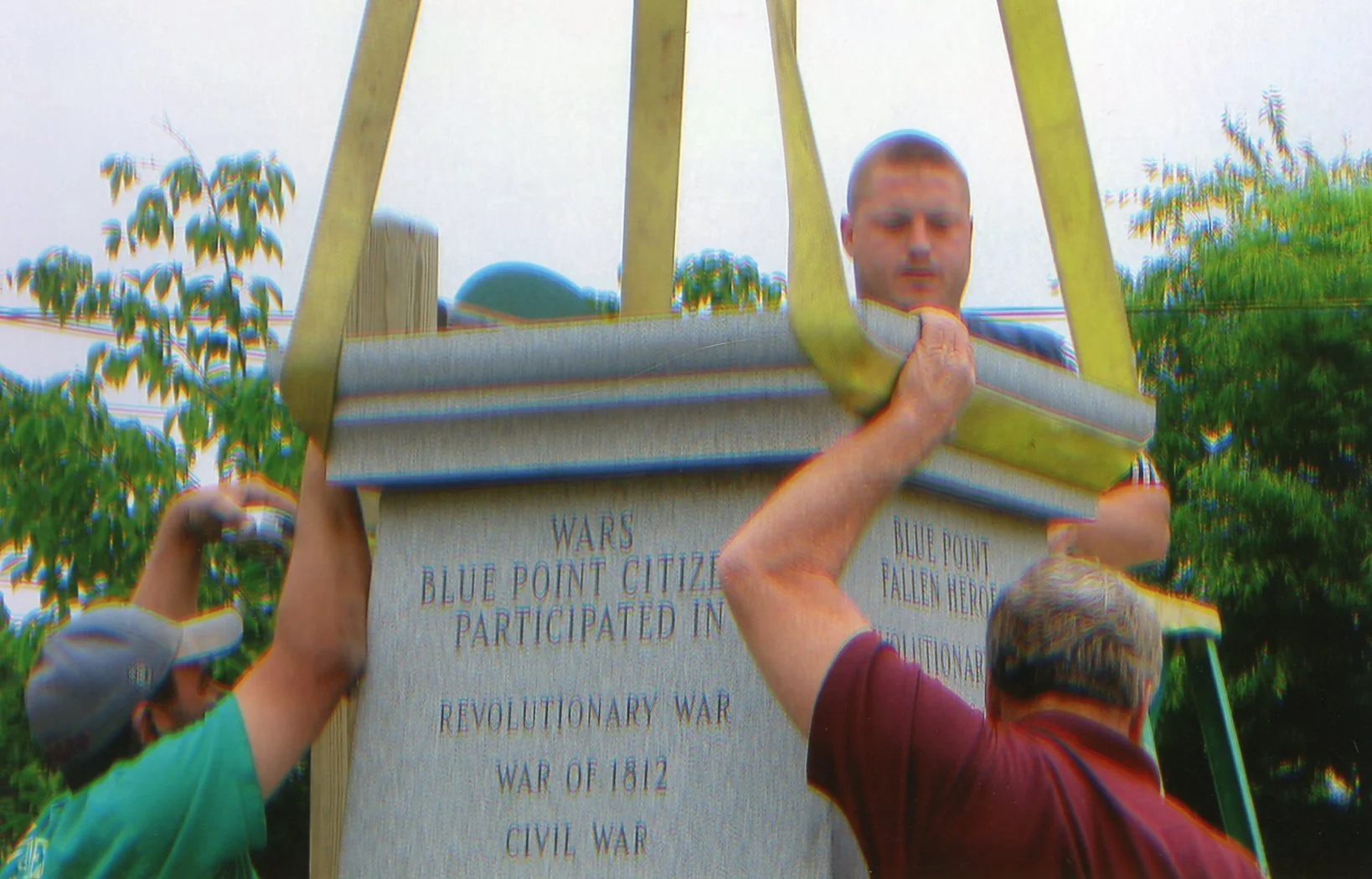 People installing a monument with engraved text about the Blue Point Citizen participation in revolutionary wars.