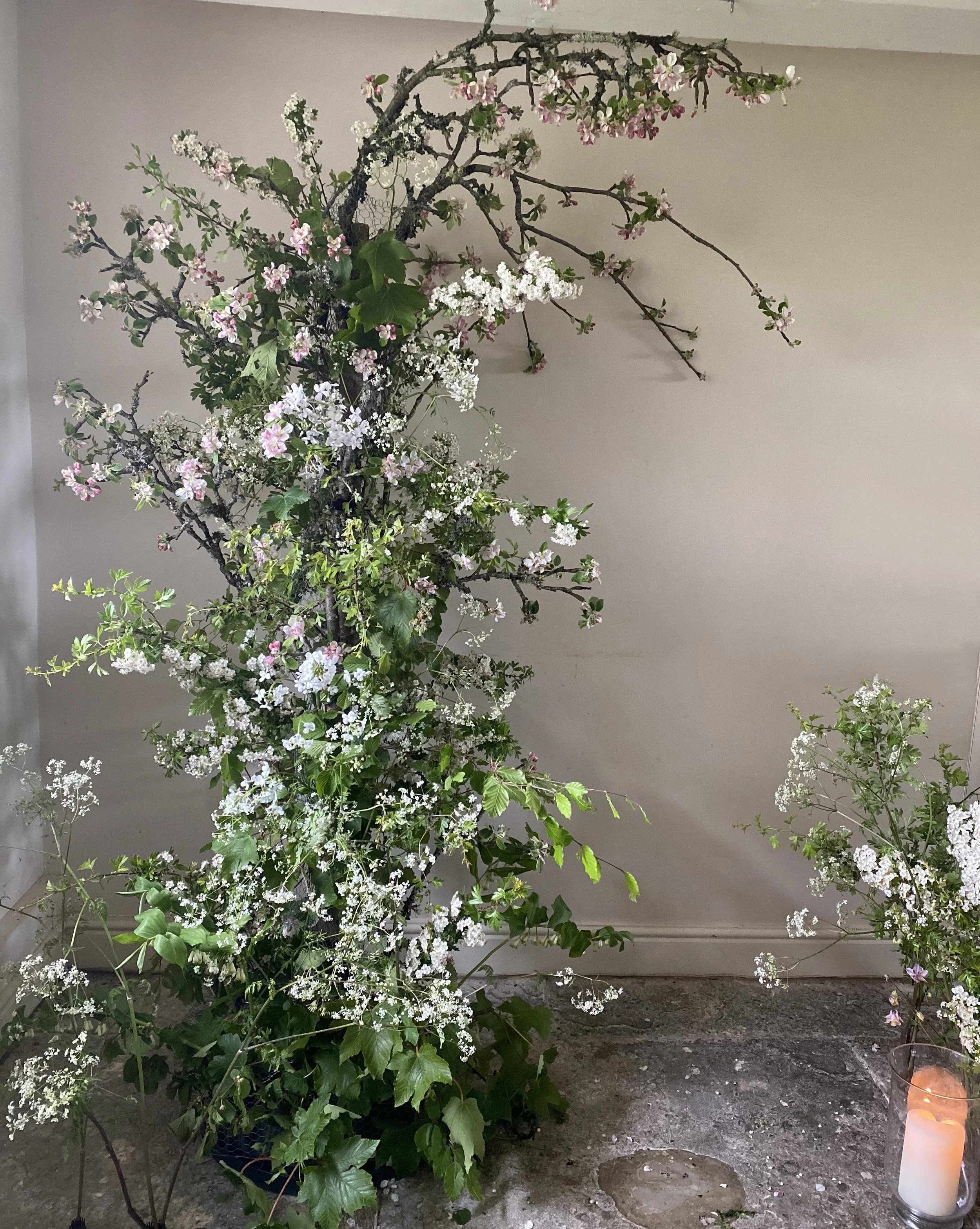 Spring wedding arch with apple blossom, hawthorn and cowparsley in soft whites and pinks