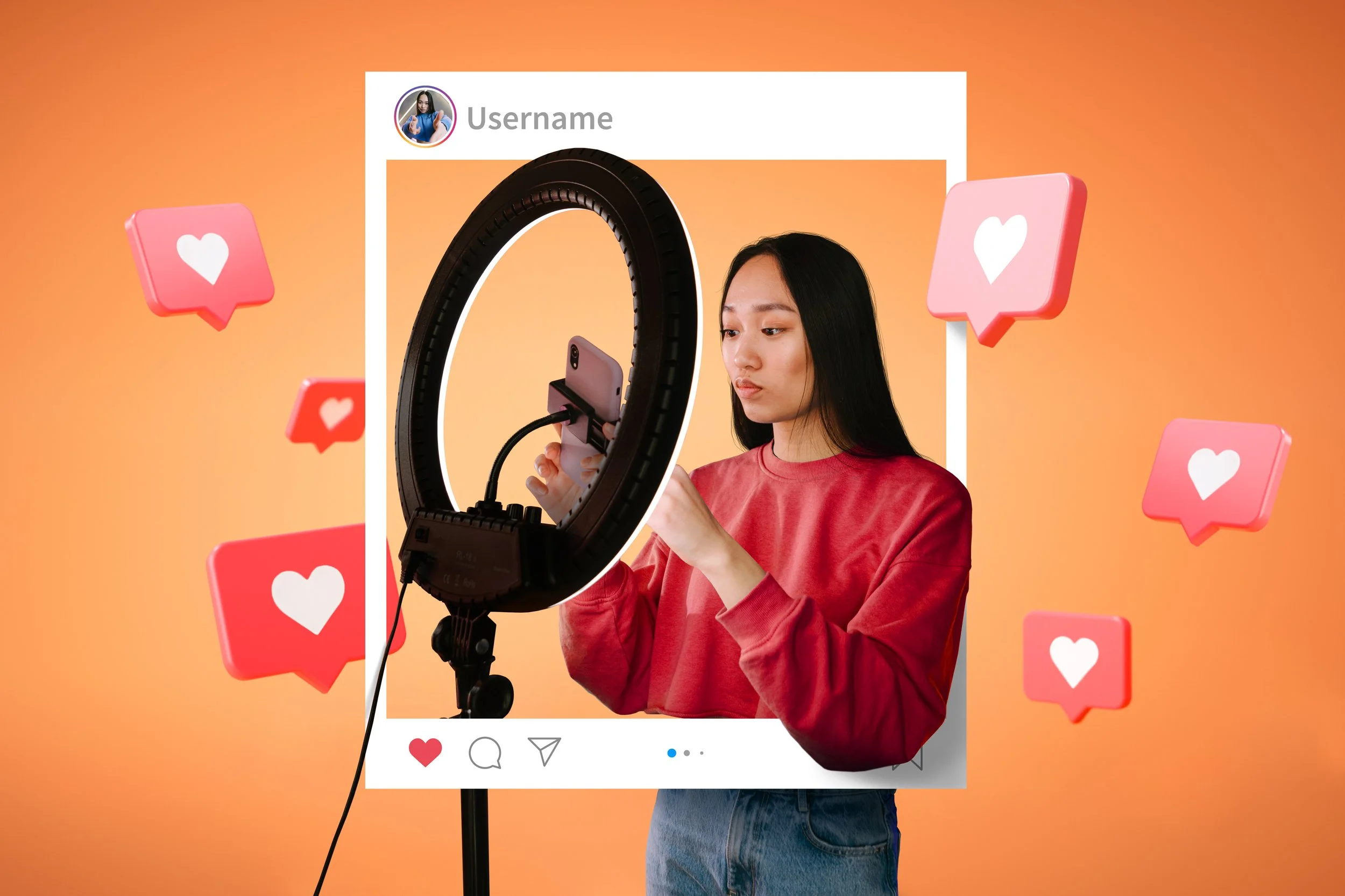 A young woman with long black hair wearing a red sweatshirt takes a photo with her phone inside a camera ring light, with an illustrated social media post frame around her and floating heart icons, against a orange background.