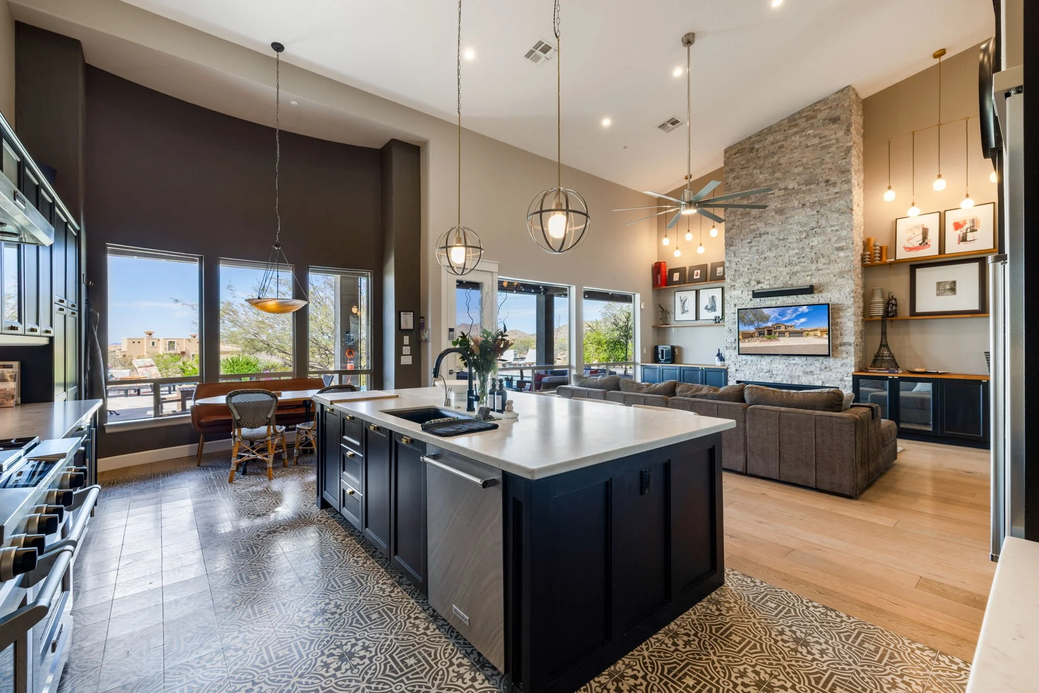 Open-concept kitchen and living room with large windows, modern lighting, and a cozy seating area in a contemporary home.