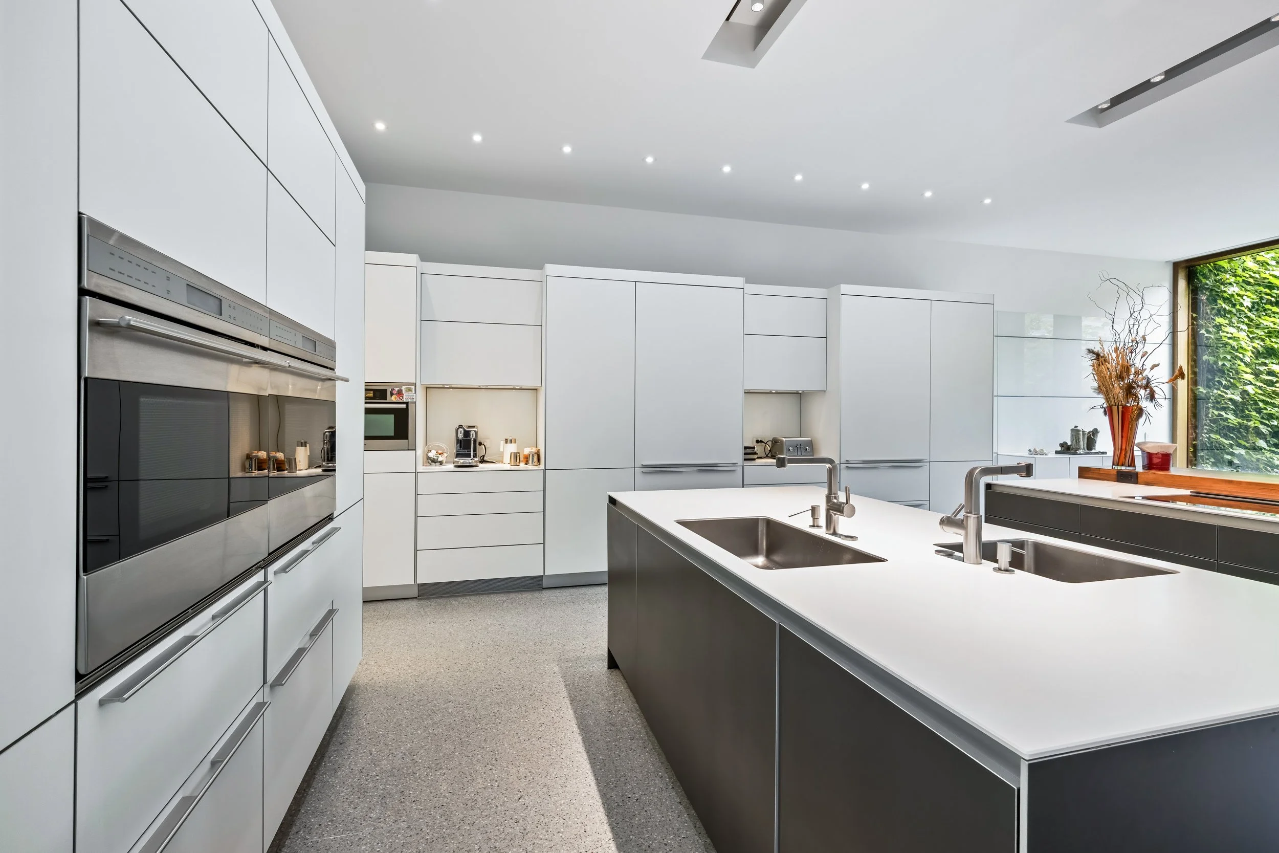 Modern minimalist kitchen design with white flat panel cabinets and custom island by Chicago kitchen build contractor in River North.