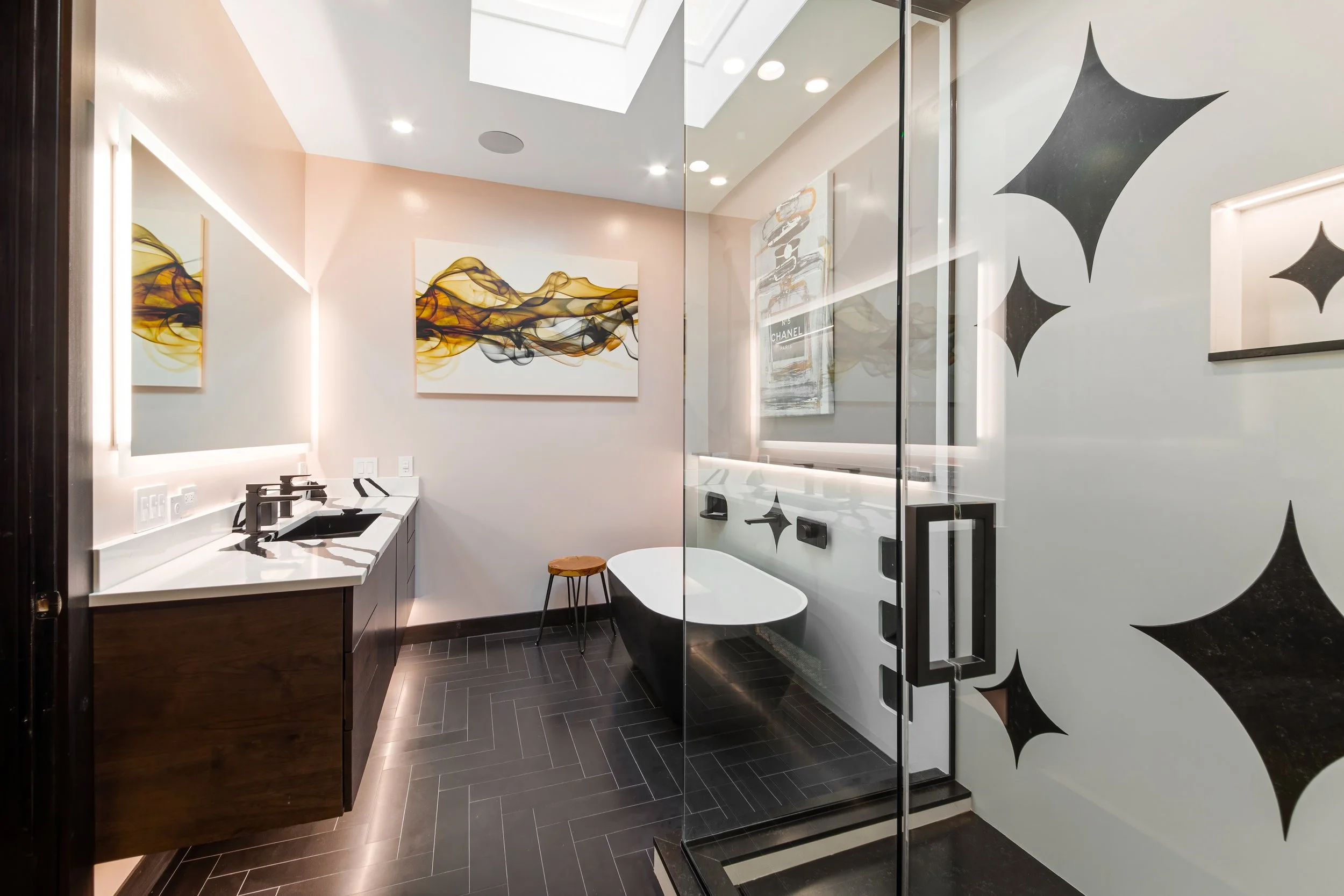 Custom luxury bathroom renovation in Chicago with black star shapes cut into wall paneling, floating dark vanity, and glass walk-in shower.