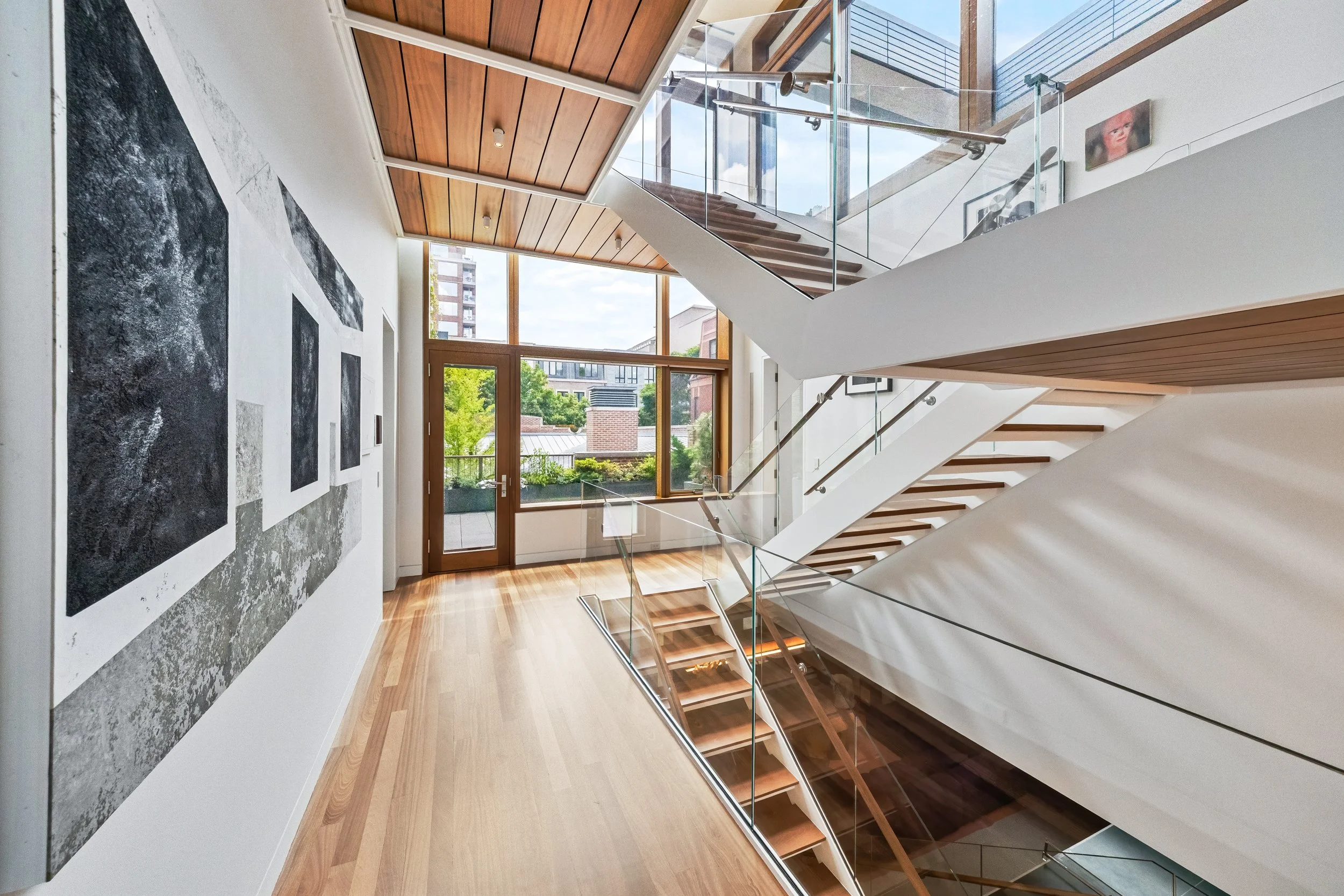 Whole home architectural redesign featuring open floating stairs and custom light wood flooring in Glencoe suburban home.