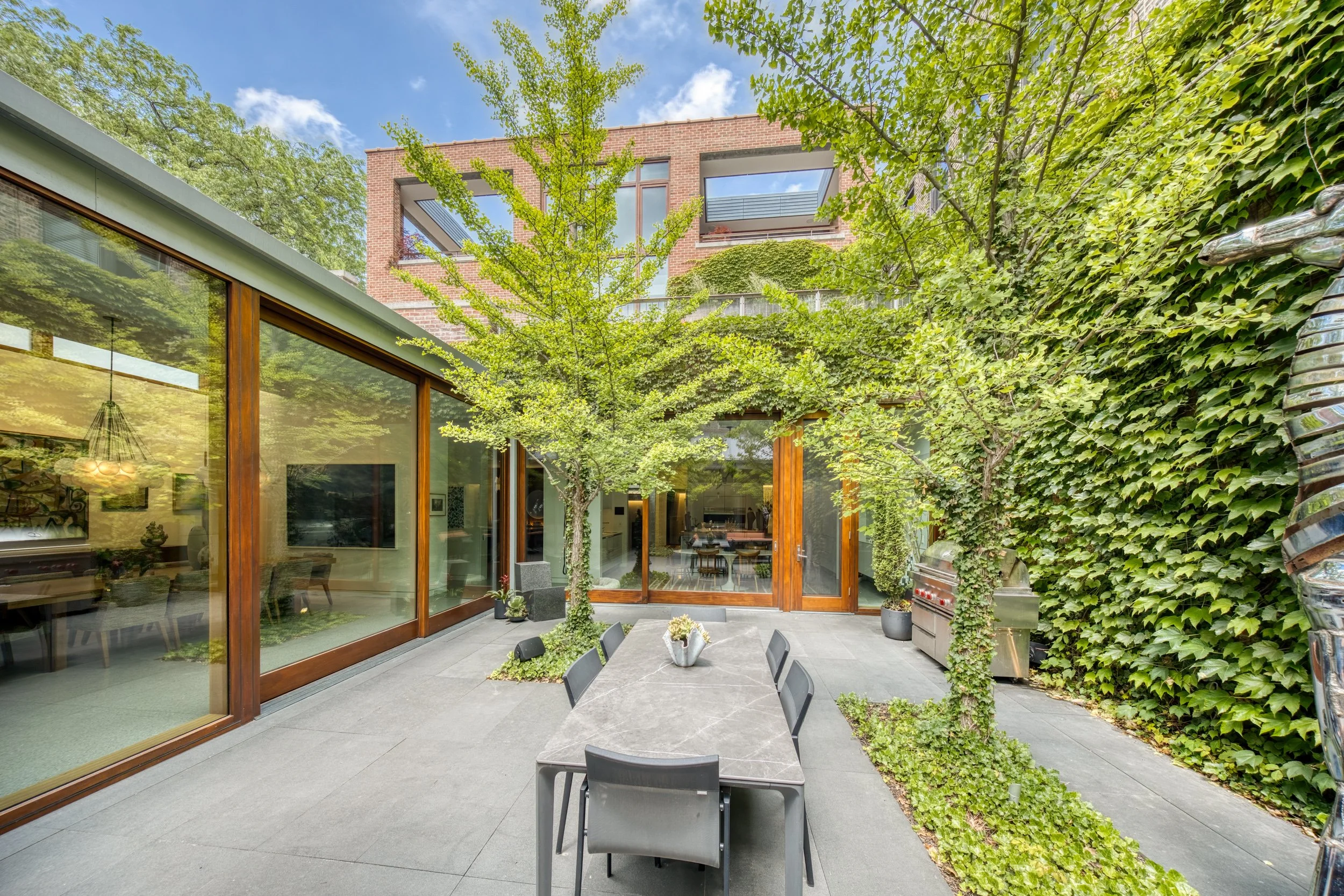 Architectural outdoor courtyard design with custom wood framing and stone patio in Wicker Park Chicago residence.