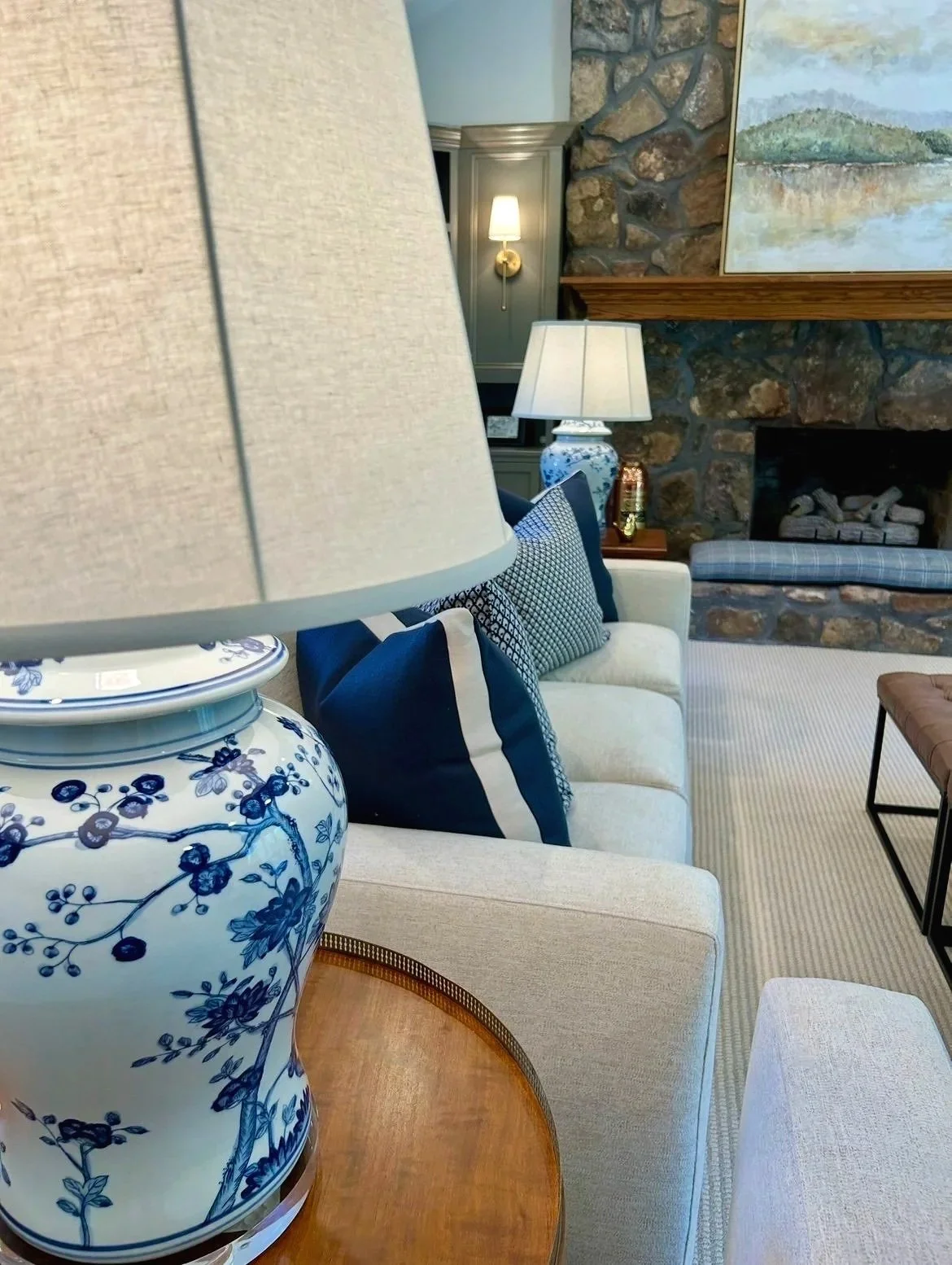 Blue and cream living room with stone fireplace and custom built-in bookcases designed by Chattanooga interior designer McLain Collins Interiors.