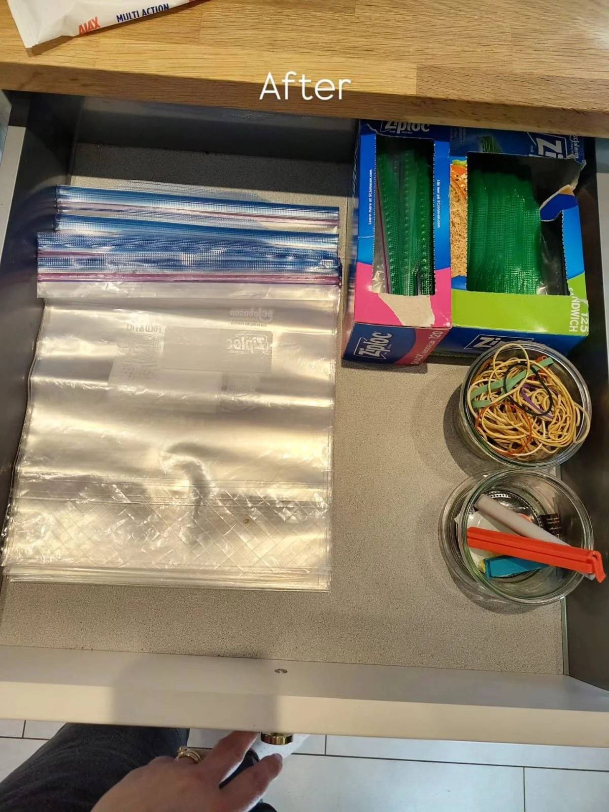 Open kitchen drawer with ziploc bags, boxes of plastic baggies, two small jars filled with rubber bands, straws, and some colored folders. The image has the word 'After' written in the center.