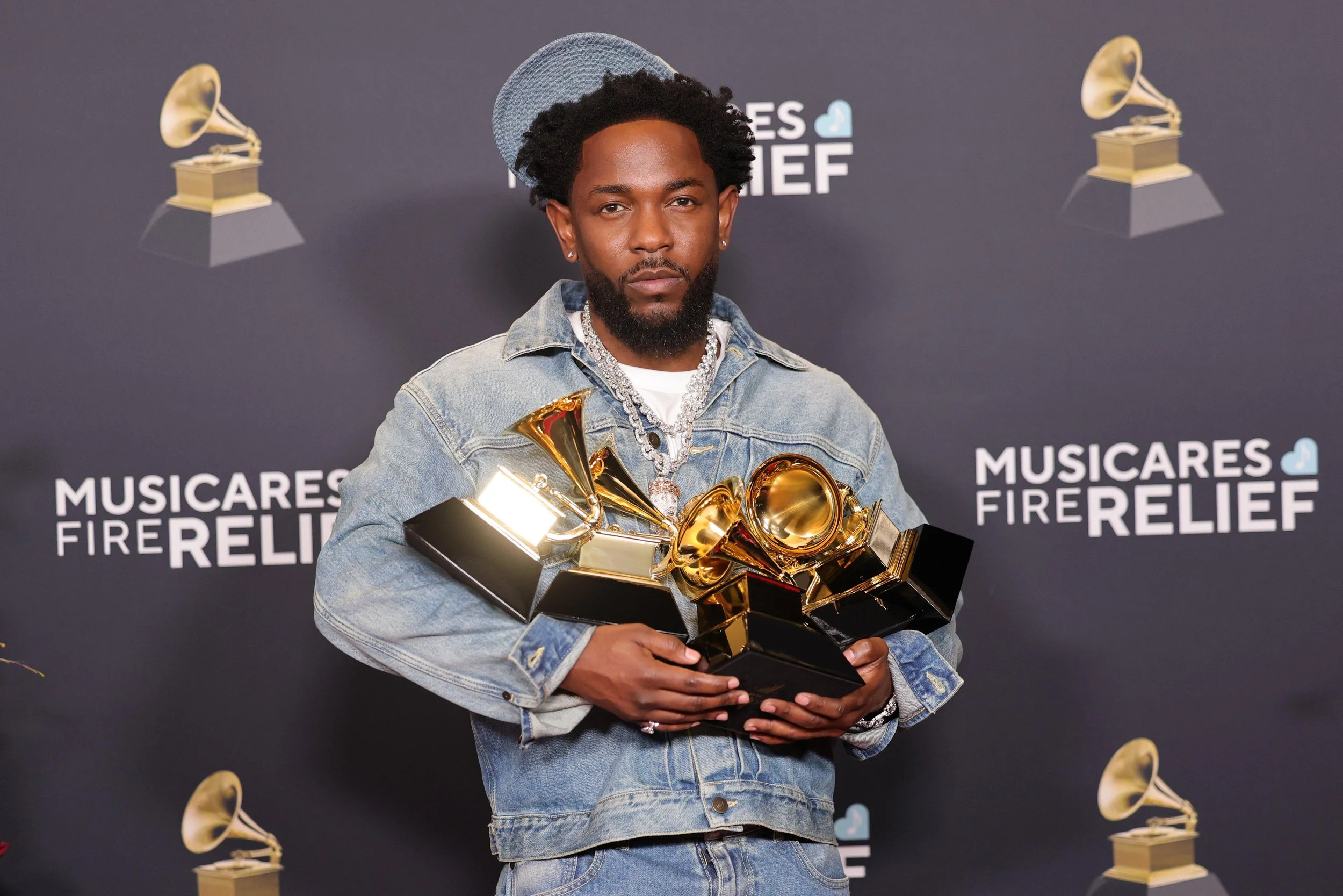 Kendrick Lamar holding his Grammy Awards