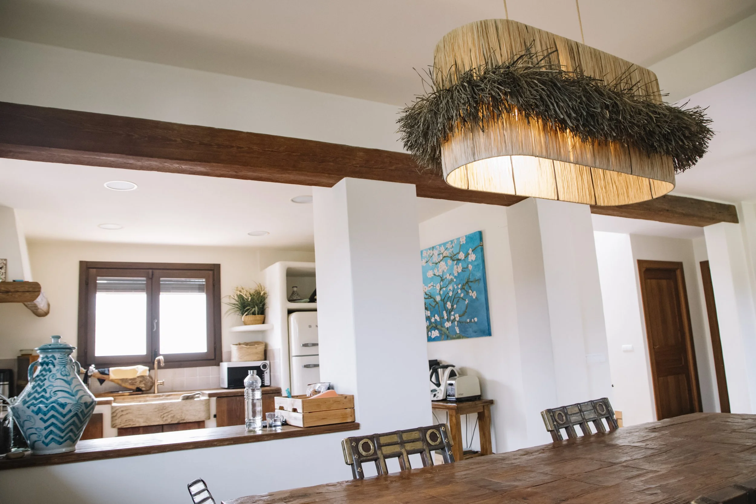 Lámpara artesanal de rafia integrada en un salón con iluminación cálida y natural.