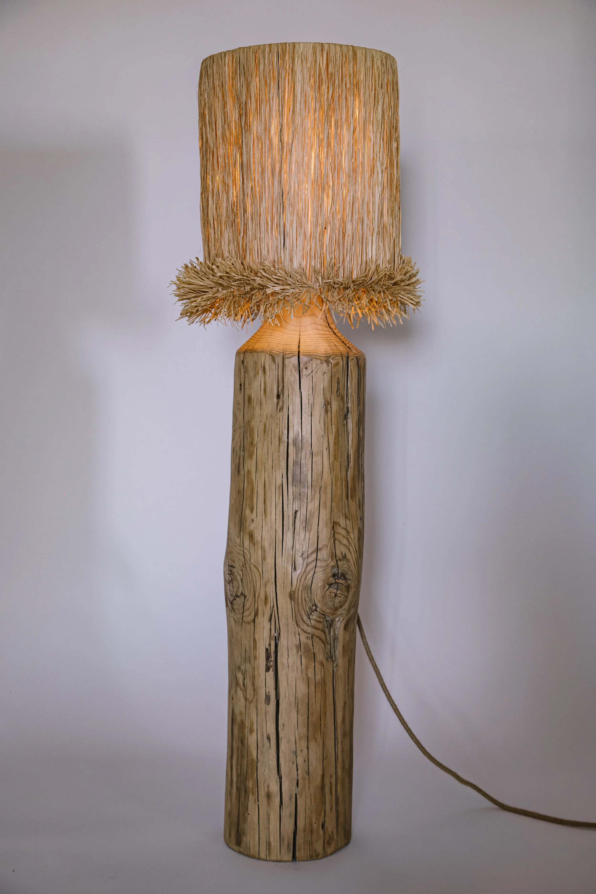 Iluminación artesanal con lamparas de madera recuperada y fibras naturales.