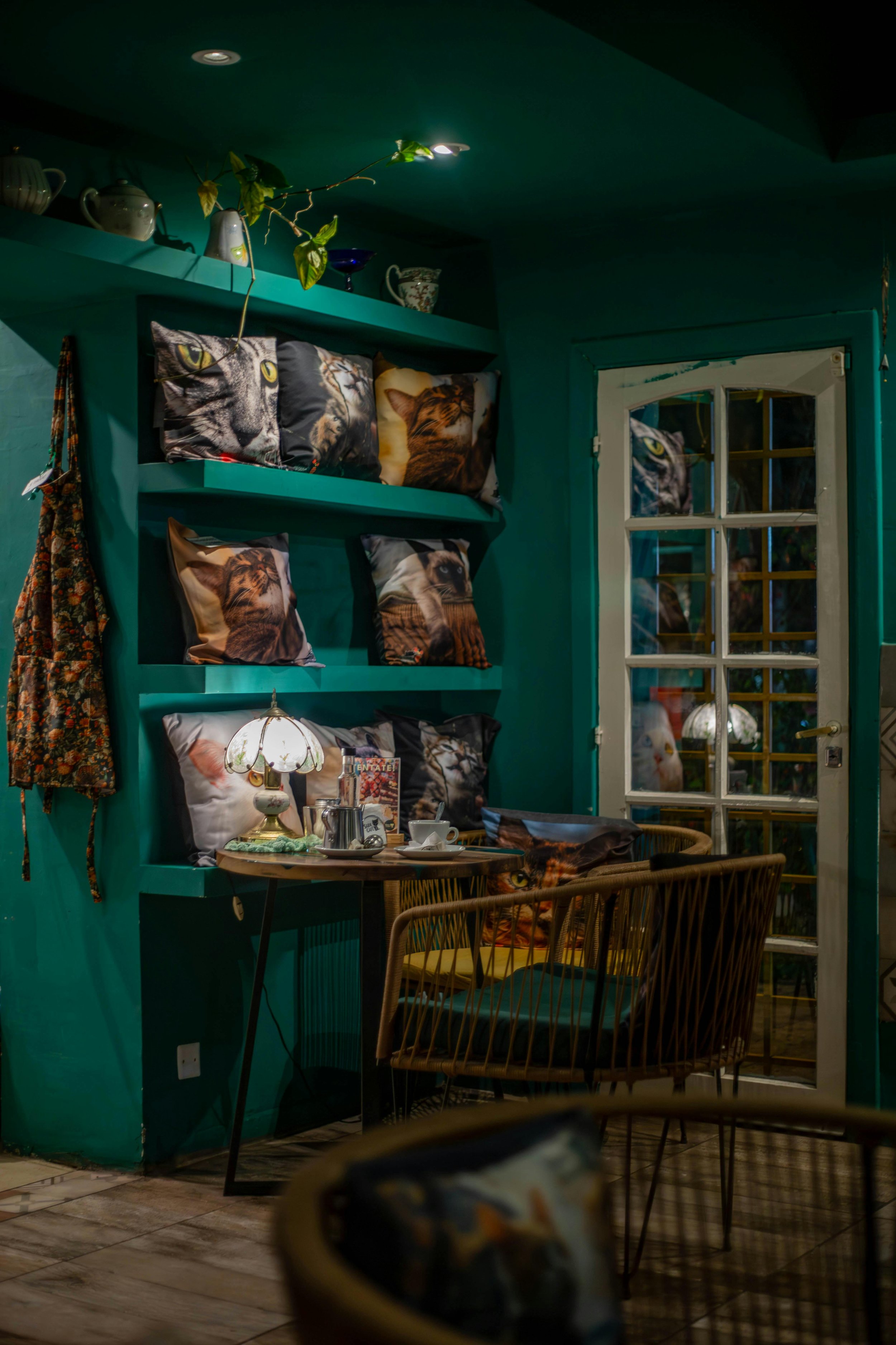 Interior con paredes verdes y diferentes puntos de luz que crean capas de iluminación y una atmósfera equilibrada.