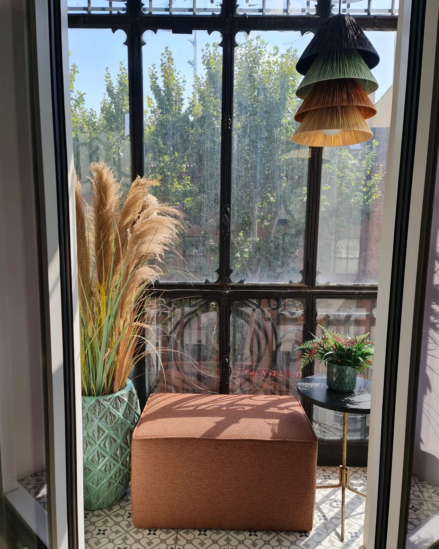 Lámpara artesanal de rafia en cuatro colores de dosana iluminando un mirador con luz natural.