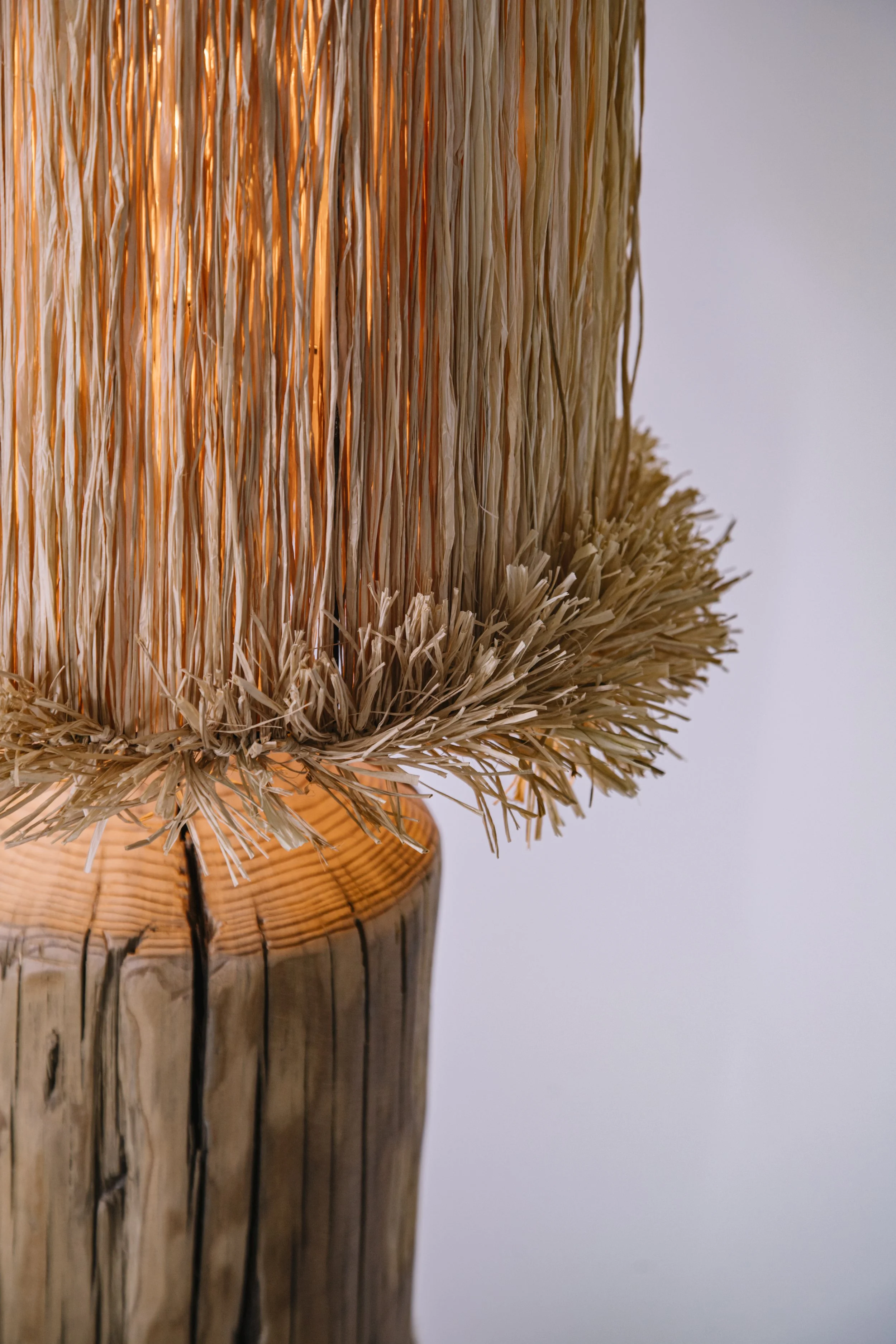 Detalle de lámpara artesanal en materiales naturales que filtra la luz de forma cálida y crea una atmósfera serena.