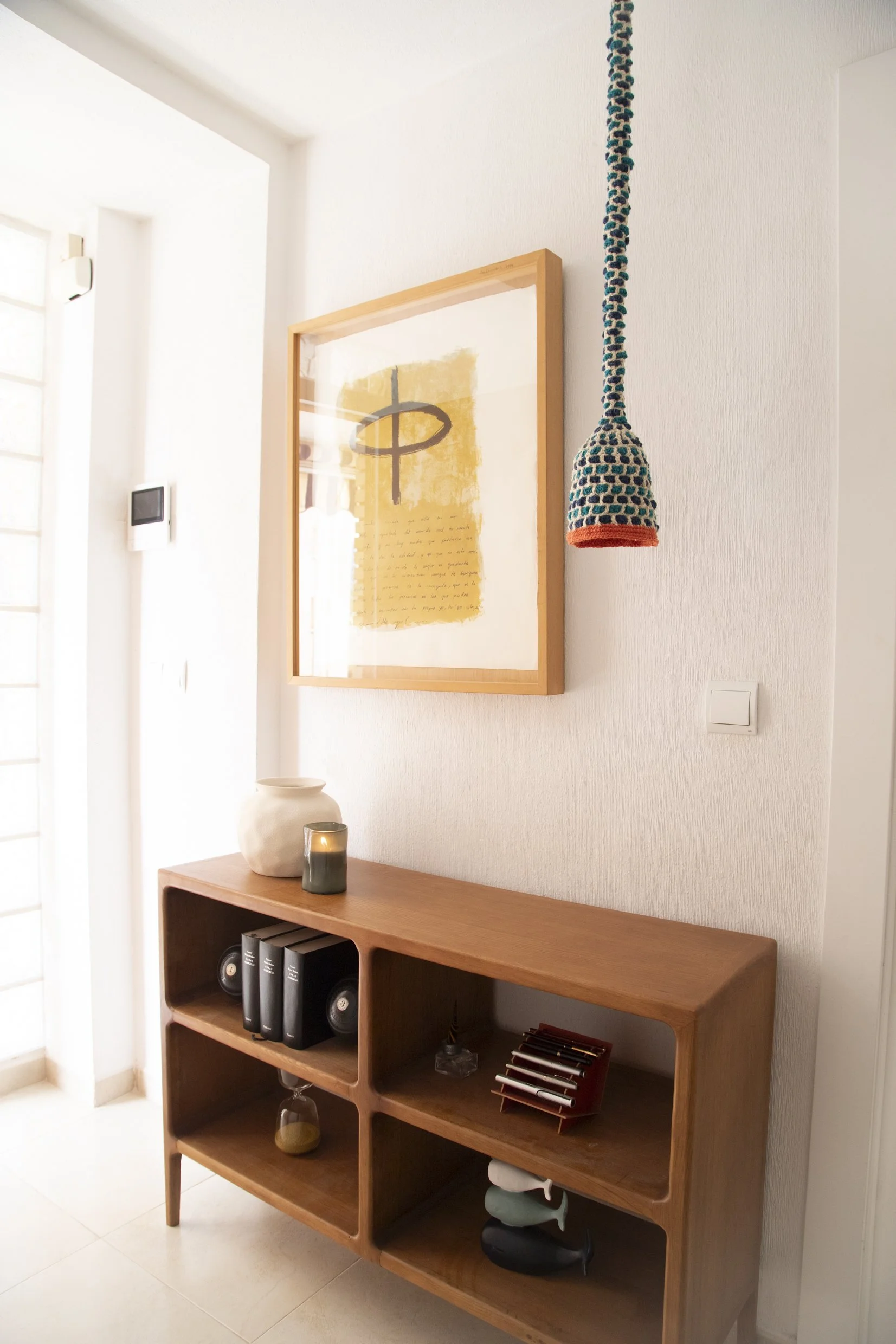 Espacio de entrada decorado con una lámpara artesanal de fibras naturales.
