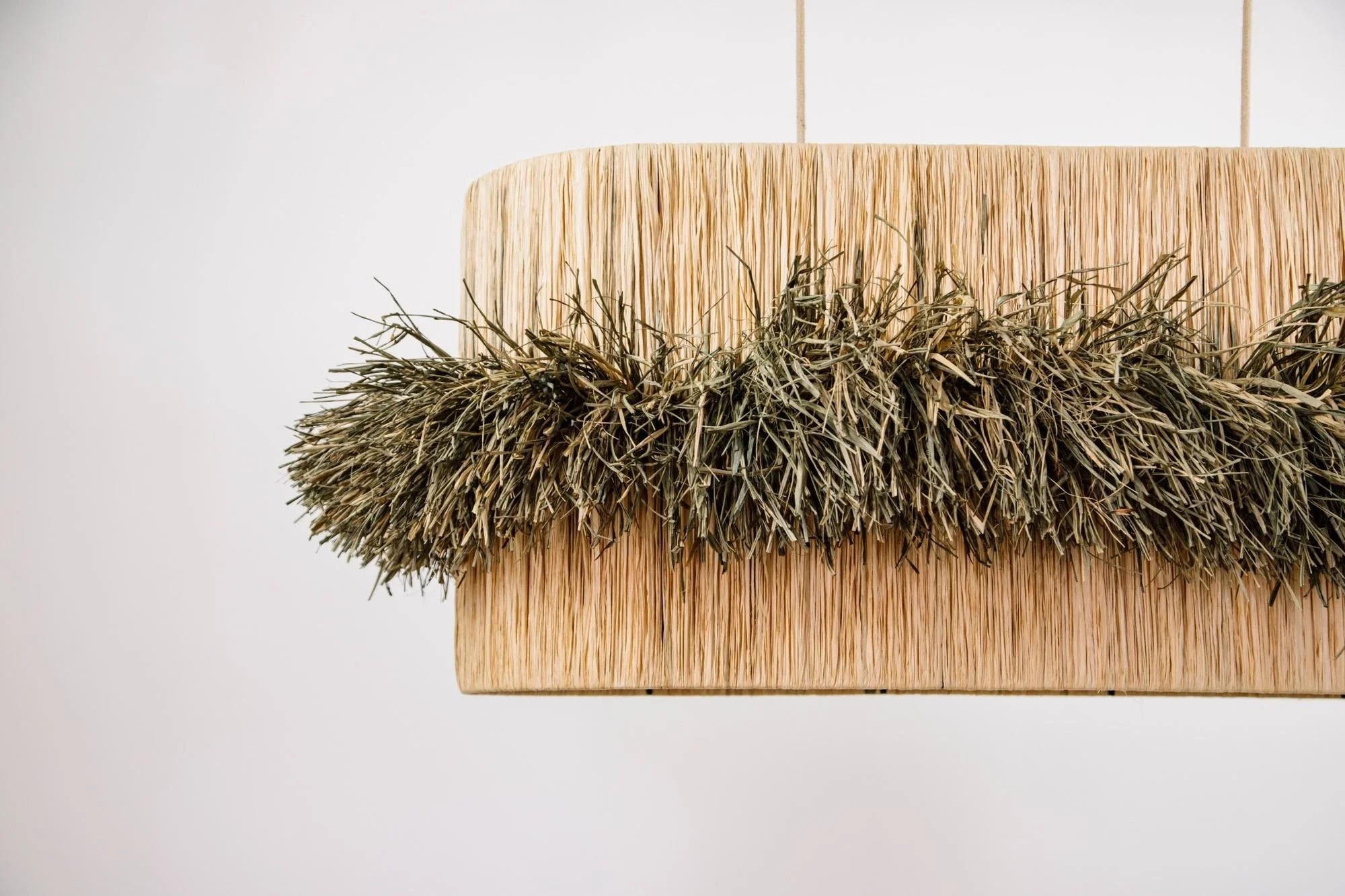 Detalle de la lámpara MANJA de rafia natural con flecos artesanales, dosana
