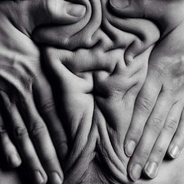 Close-up black and white photograph of multiple hands and fingers intertwined and touching.