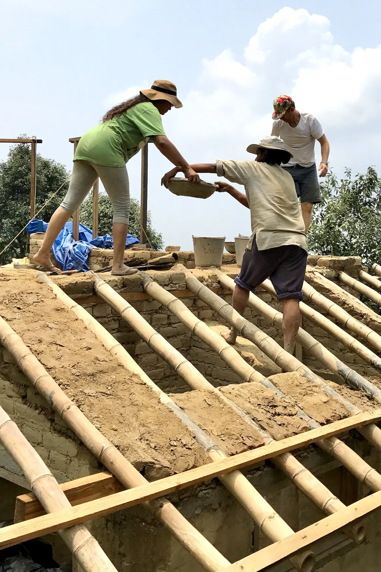 Passing bins of mud for adobe building
