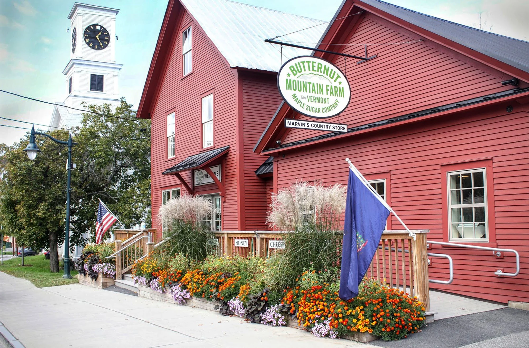 A portrait of Marvin's Country Store's red exterior with flowers in bloom.