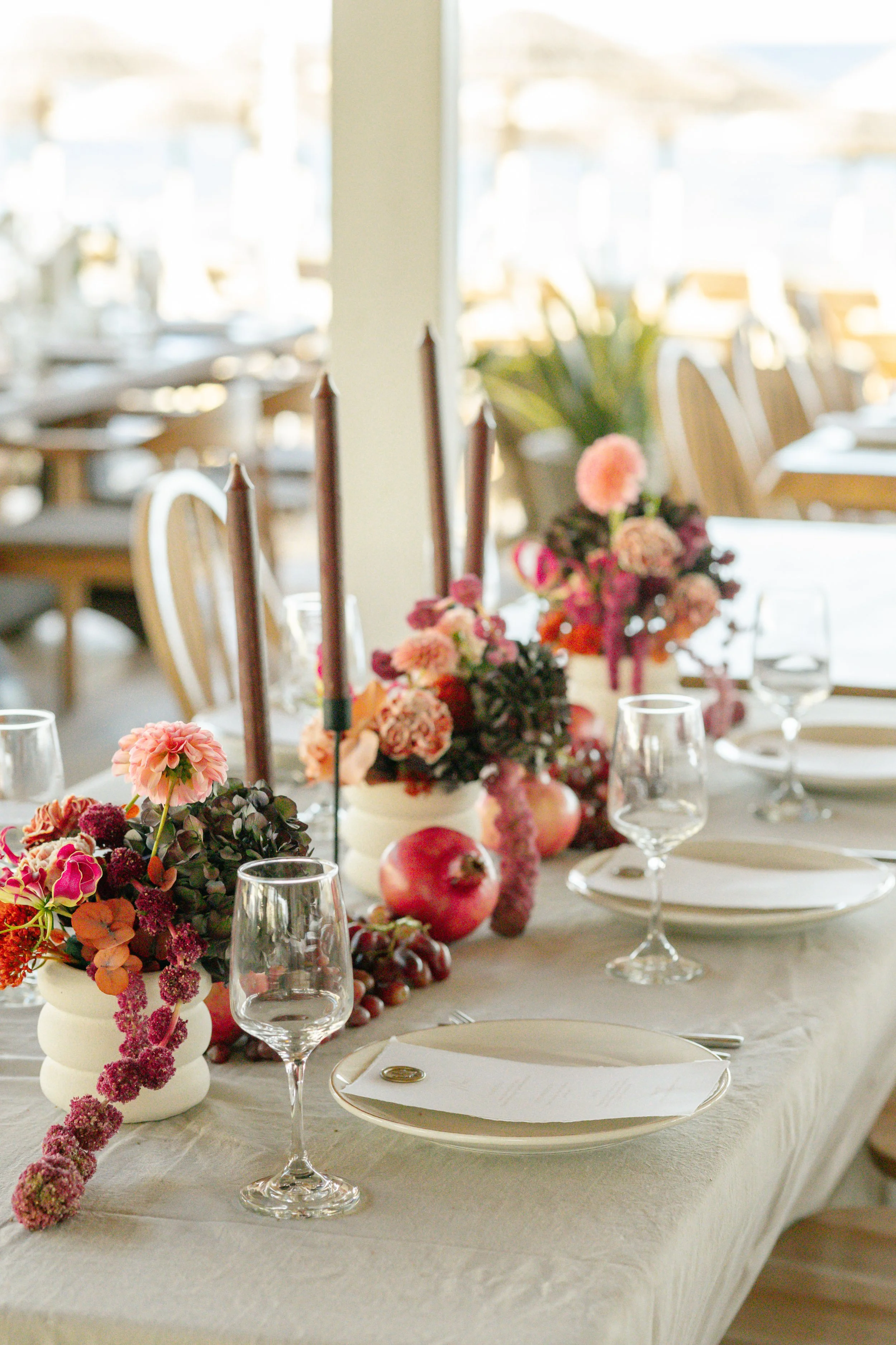 Elegant dining table setting  in Athens surrounded with floral arrangements, candles, wine glasses, capturing the essence of a destination wedding in Greece