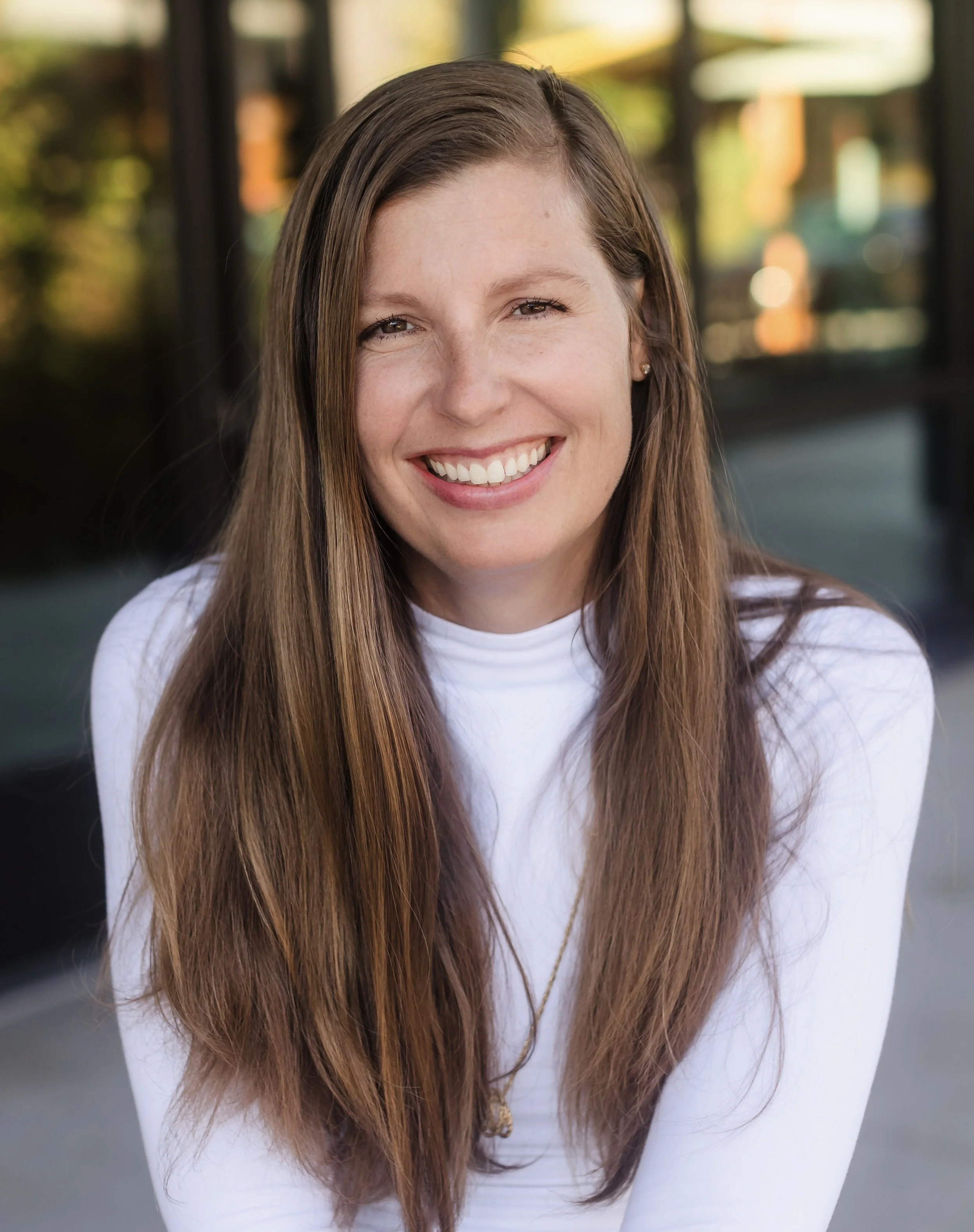 Anna McCormick, smiling woman with long brown hair and white shirt