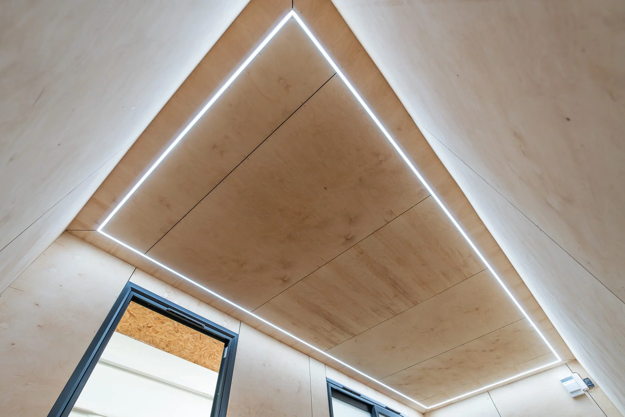 Ceiling with wooden panels and integrated LED lighting in a modern interior space