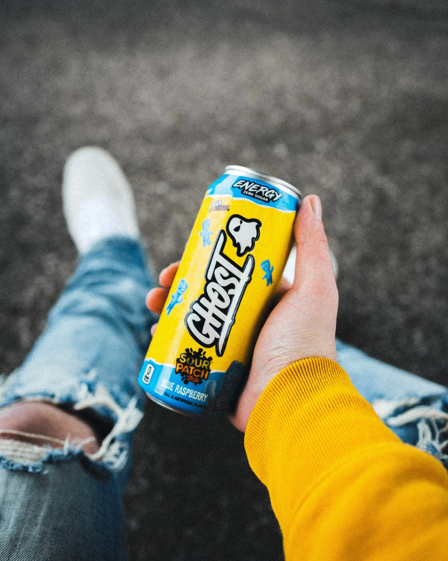 Hand holding a Ghost Energy drink can during an outdoor lifestyle photoshoot.