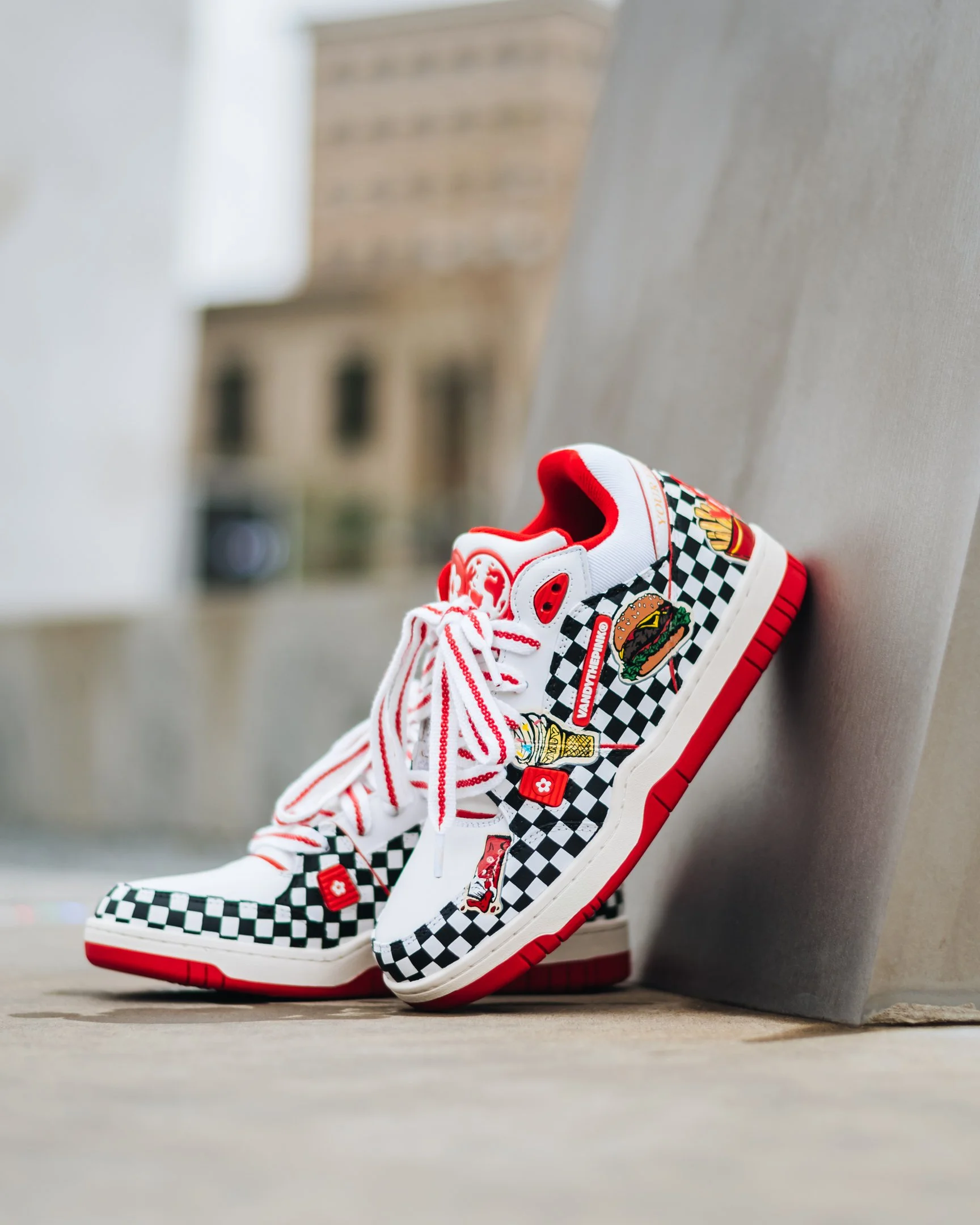 Vandy the Pink custom sneaker by Sneaker Queens Customs photographed against a city concrete wall.