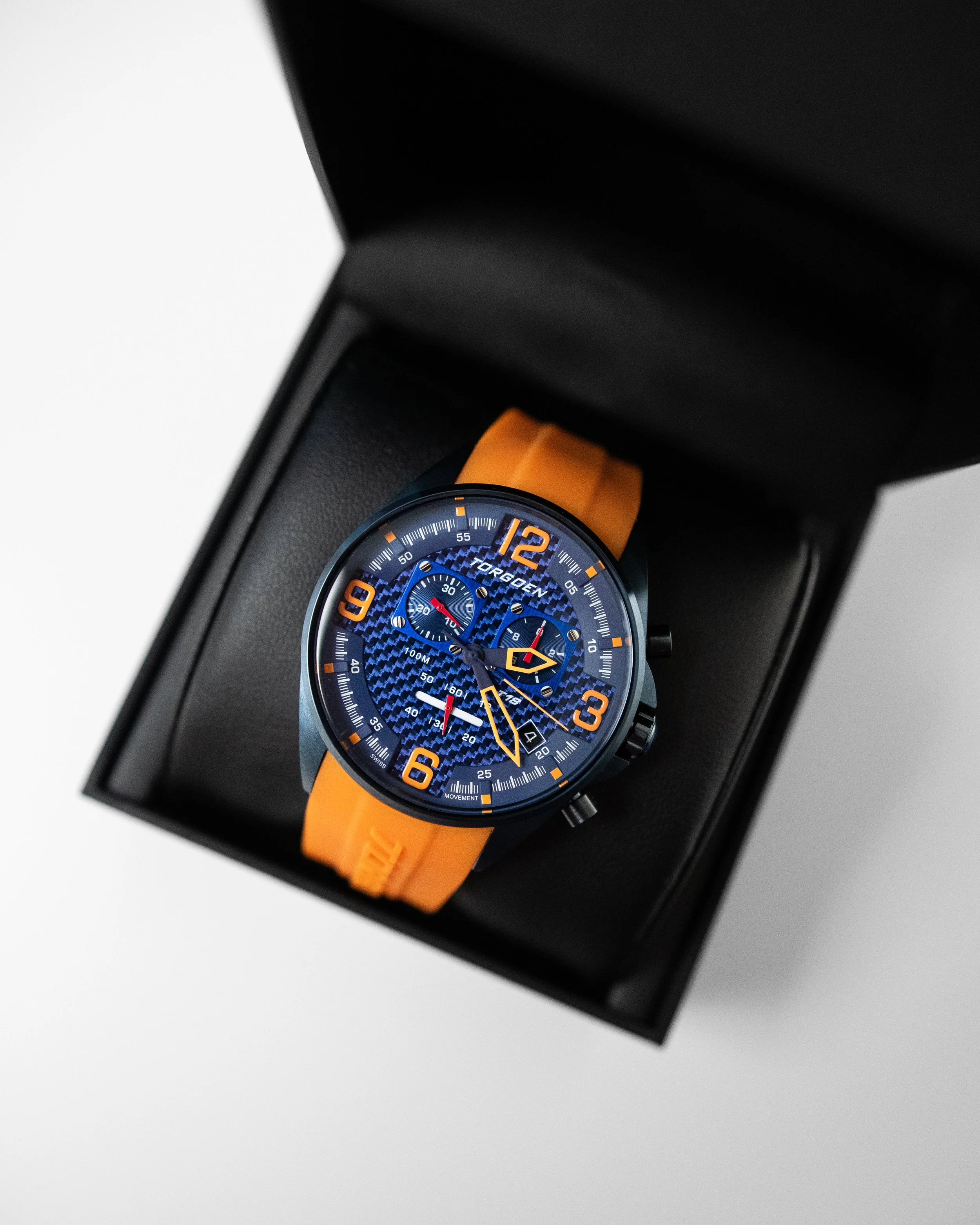 Torgoen T18 aviation watch with orange strap in black presentation box on white background, professional product photo.