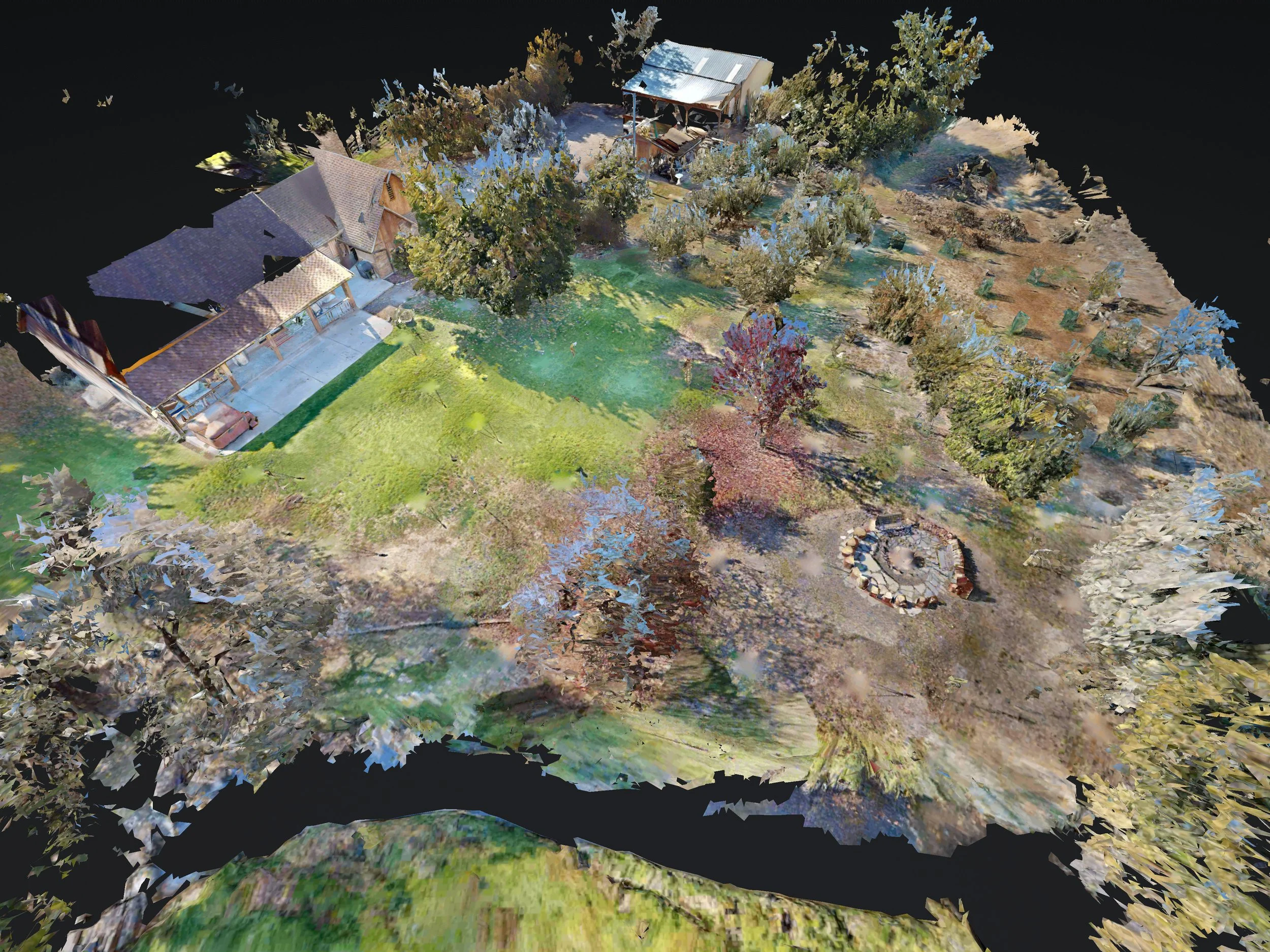 Aerial view of a backyard with houses, trees, grass, and a fire pit.