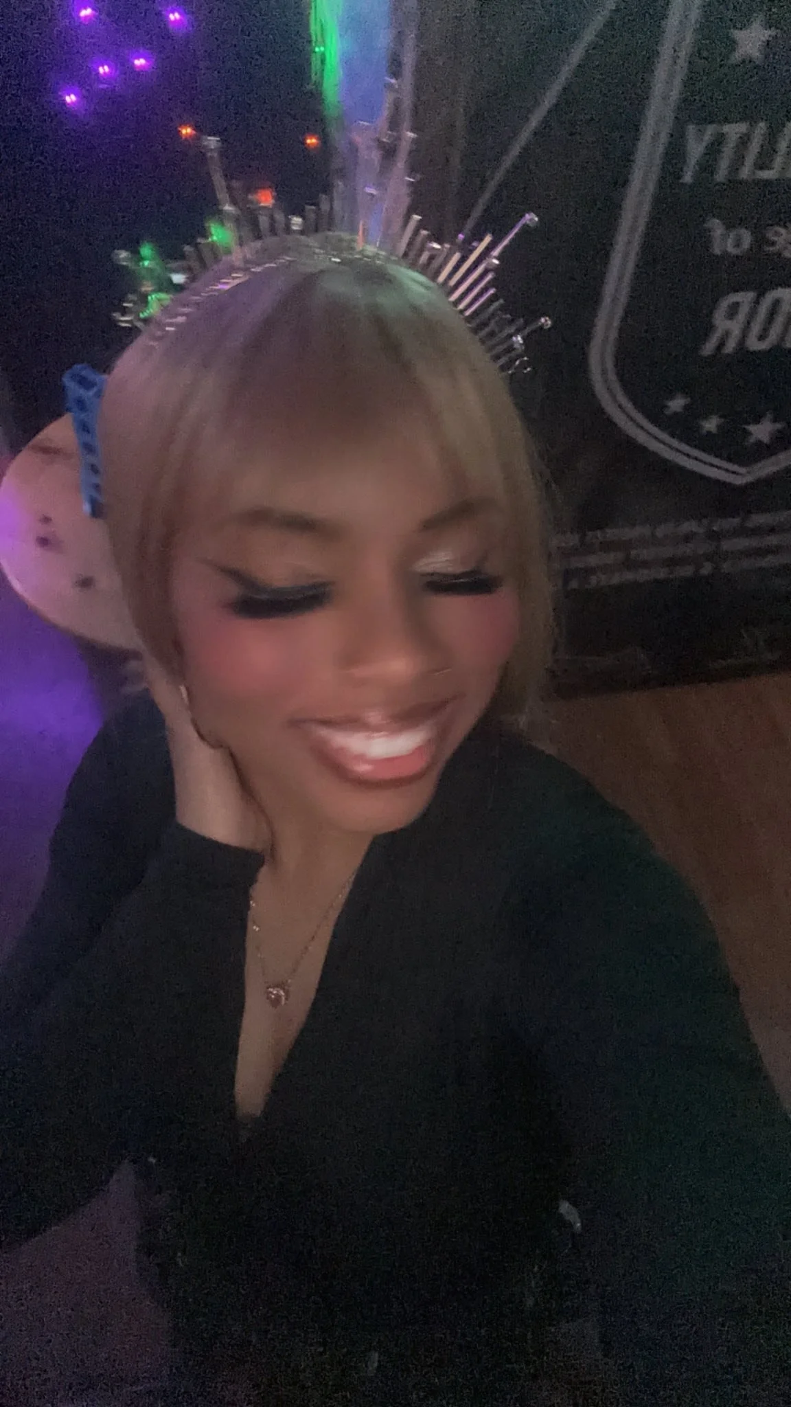 Mani Da Brat independent female hip-hop and R&B artist wearing LED crown in colorful nightlife setting smiling with eyes closed