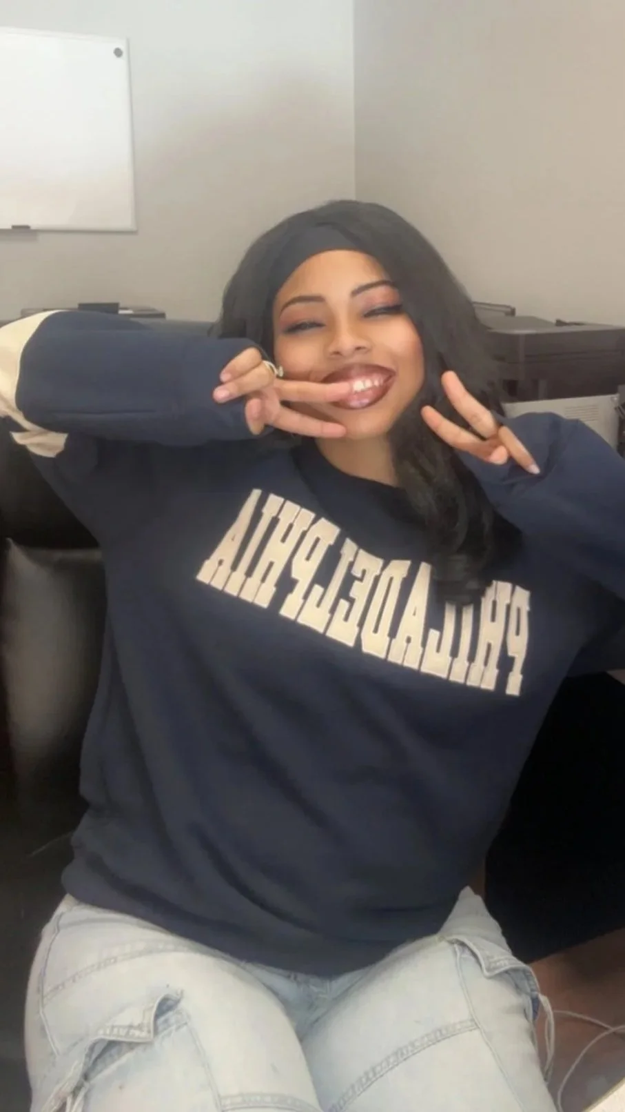 Mani Da Brat independent female hip-hop and R&B artist smiling and making peace signs in casual indoor setting