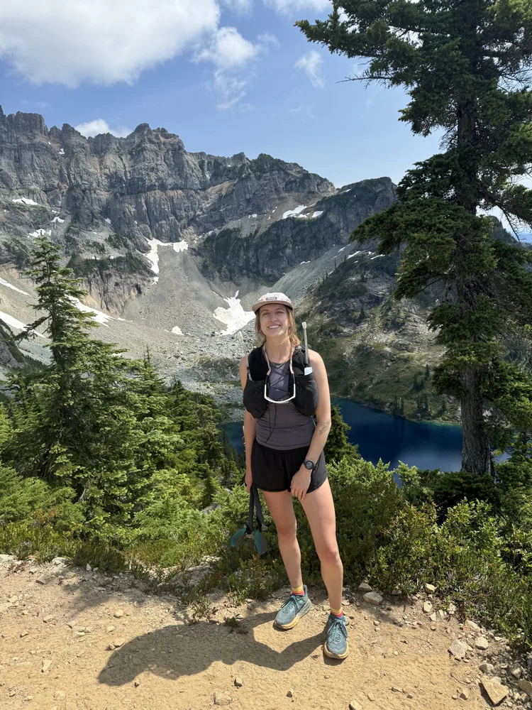 Lindsay Alexander, DPT, pelvic floor physical therapist in Seattle, on a mountain trail above an alpine lake