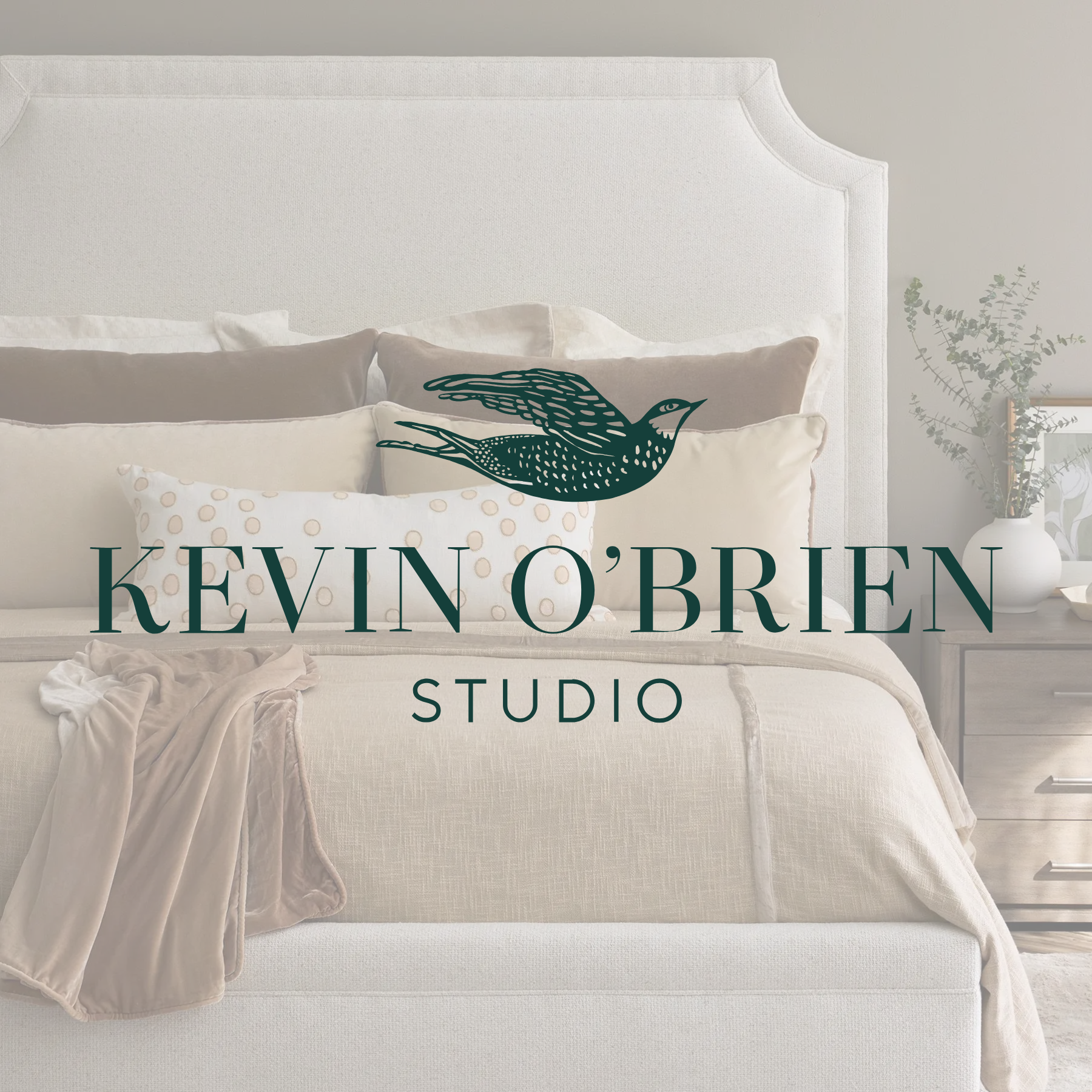 Stack of white textiles with 'Kevin O'Brien Studio' logo featuring a flying bird.