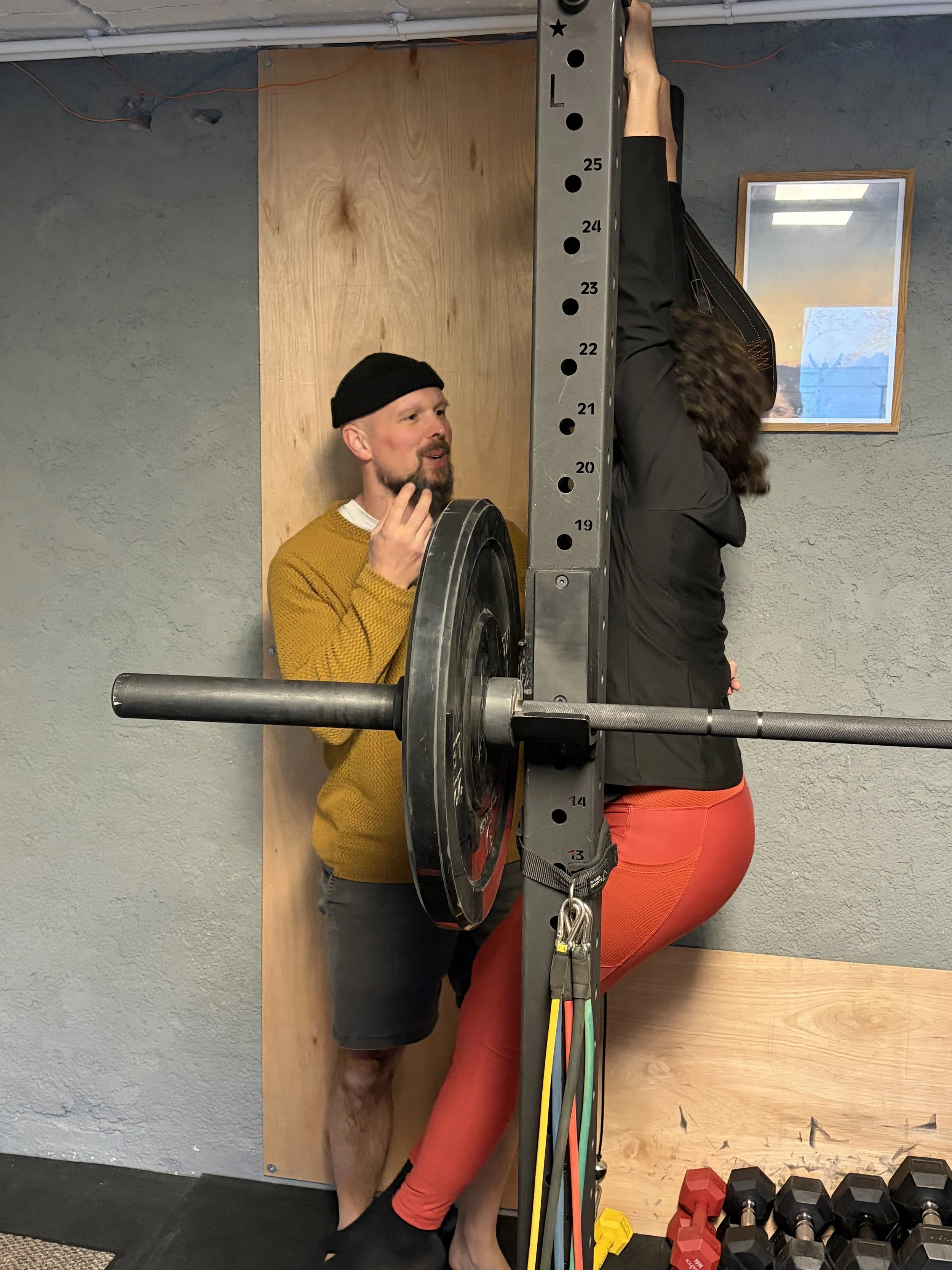 Le coach donne des indications de placement à sa cliente sur un mouvement suspendu