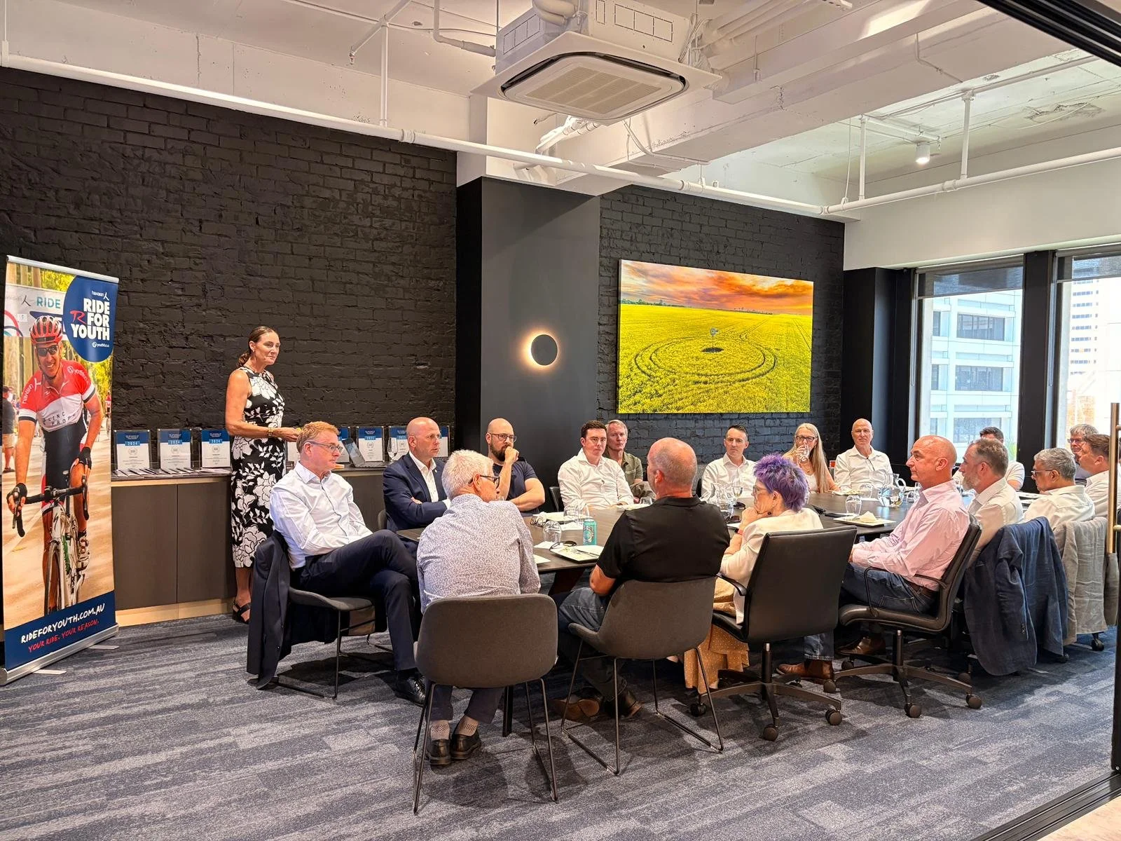 Executive leaders discussing workplace mental health strategies at the Ride for Youth fundraising event.