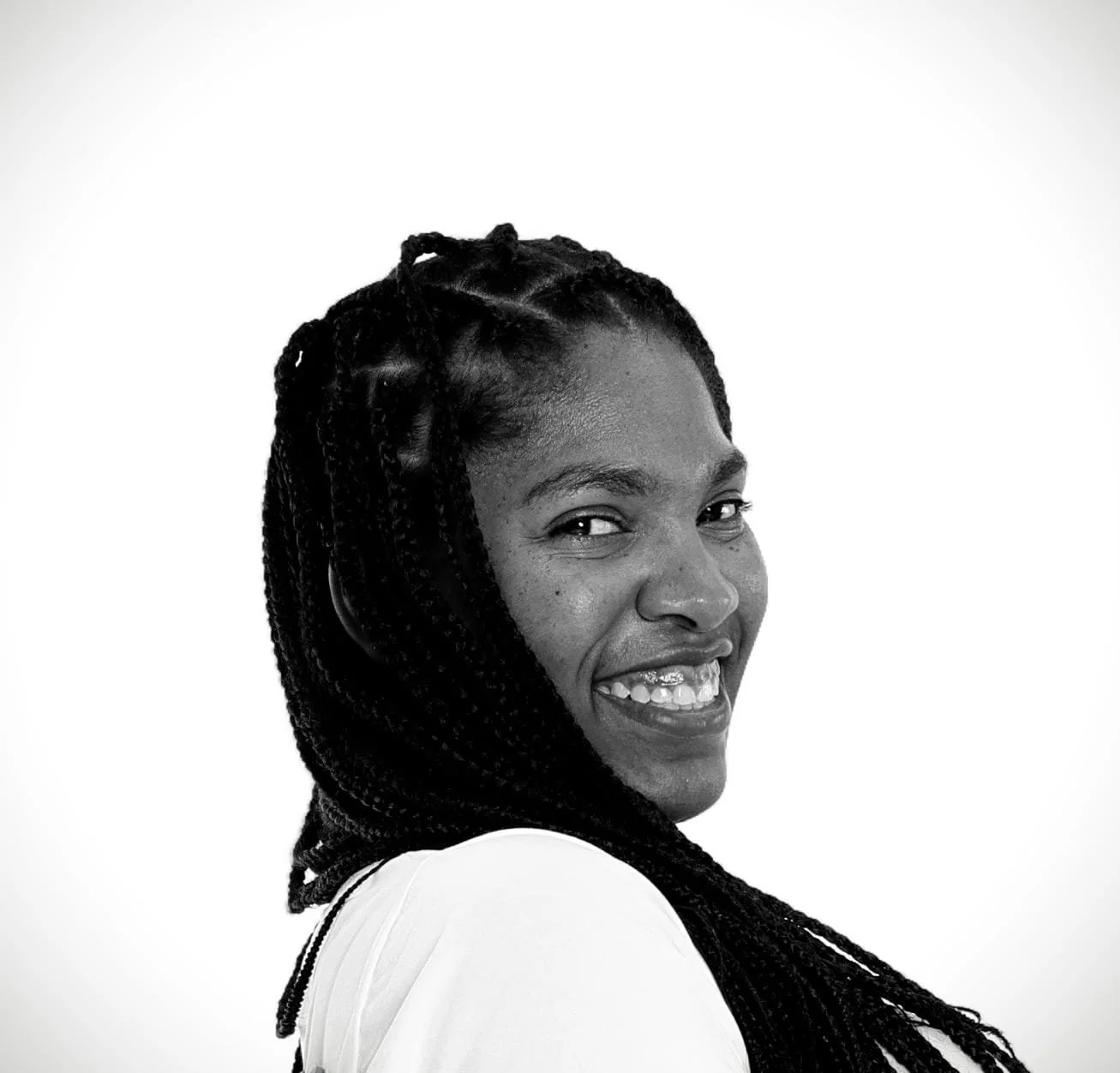 Black and white portrait of a smiling woman with braided hair, facing slightly to the right.