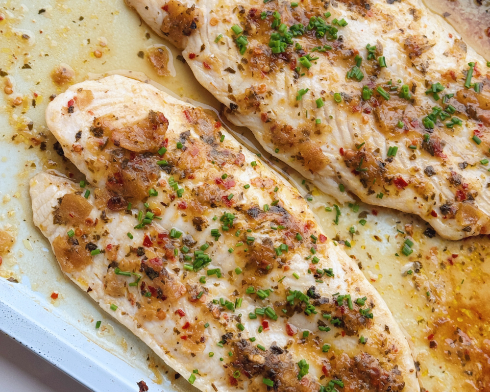  Grilled basa on a baking tray with lemon chimichurri and chopped chives 