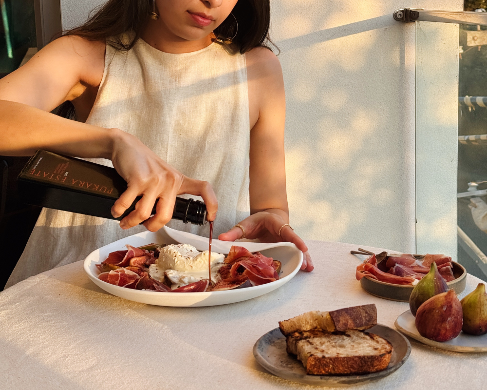  Karina drizzling fig balsamic vinegar over burrata, grilled figs and prosciutto platter 