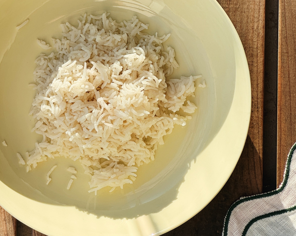  Steamed basmati rice in a yellow bowl, served as part of a brothy coconut curry with chicken 